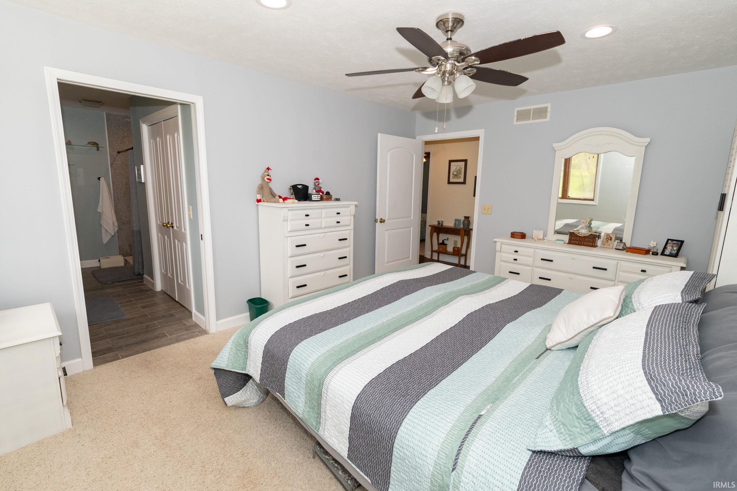 Bedroom featuring plush carpeting, recessed lighting, and a ceiling fan with light fixture