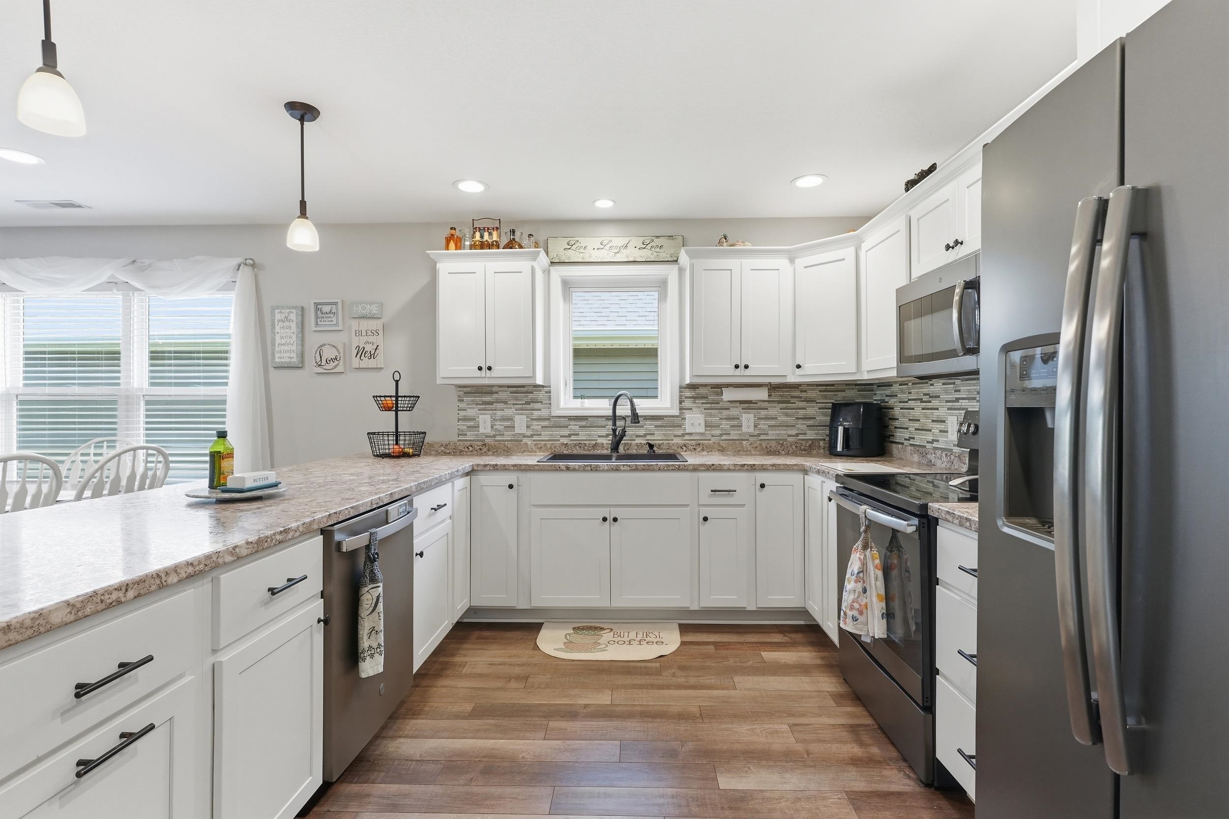 Kitchen featuring white cabinetry, stone-finish countertops, stainless steel appliances, wood-finish flooring, and recessed lighting