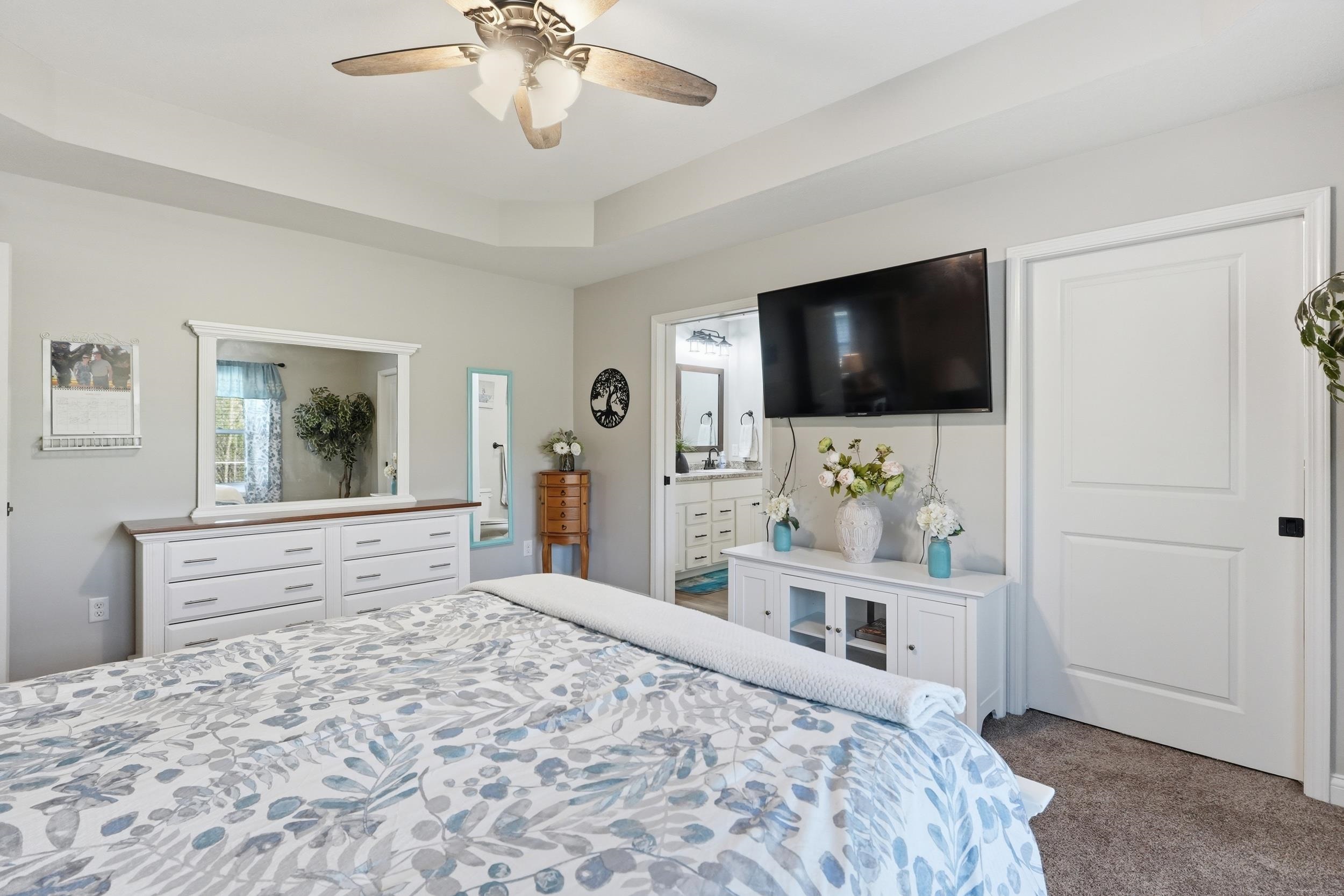 Tray ceiling featuring a ceiling fan with integrated lighting