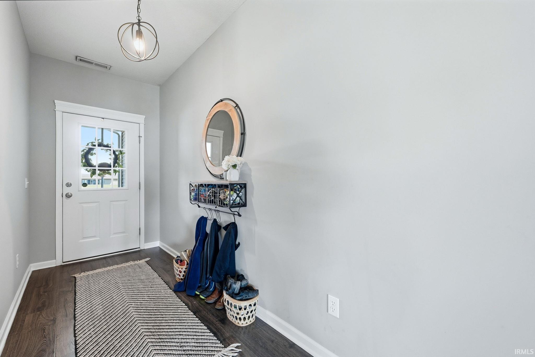 Entryway featuring wood-finish flooring, light grey walls, and white trim