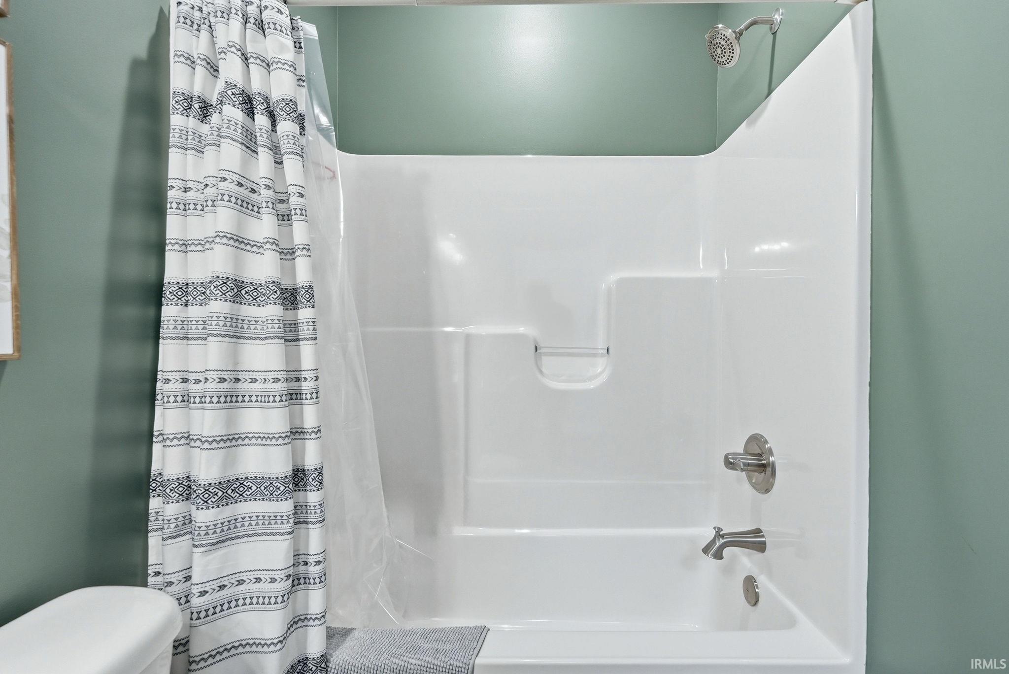 White fiberglass tub and shower combination with brushed nickel fixtures