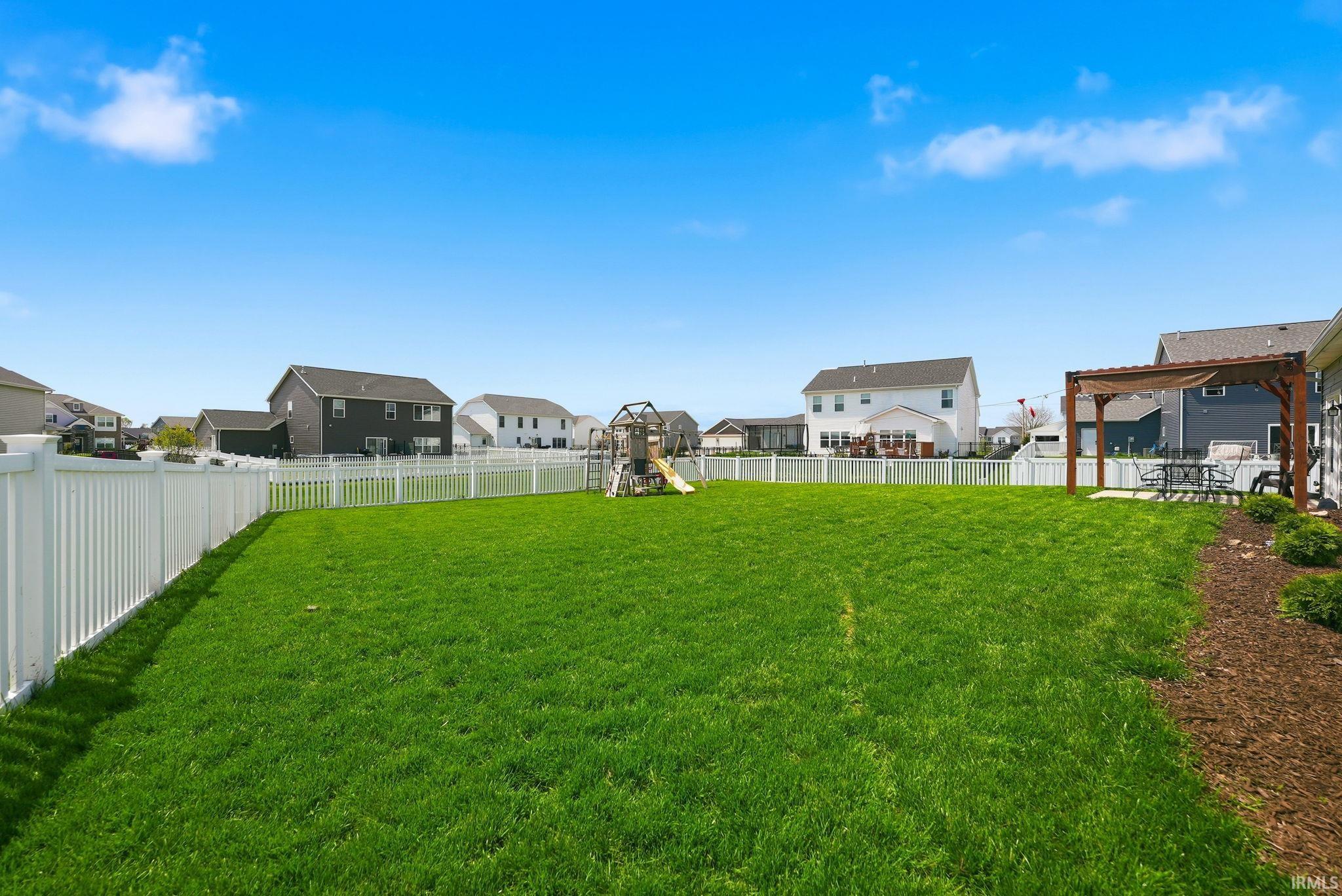 Expansive green lawn enclosed by white vinyl fencing