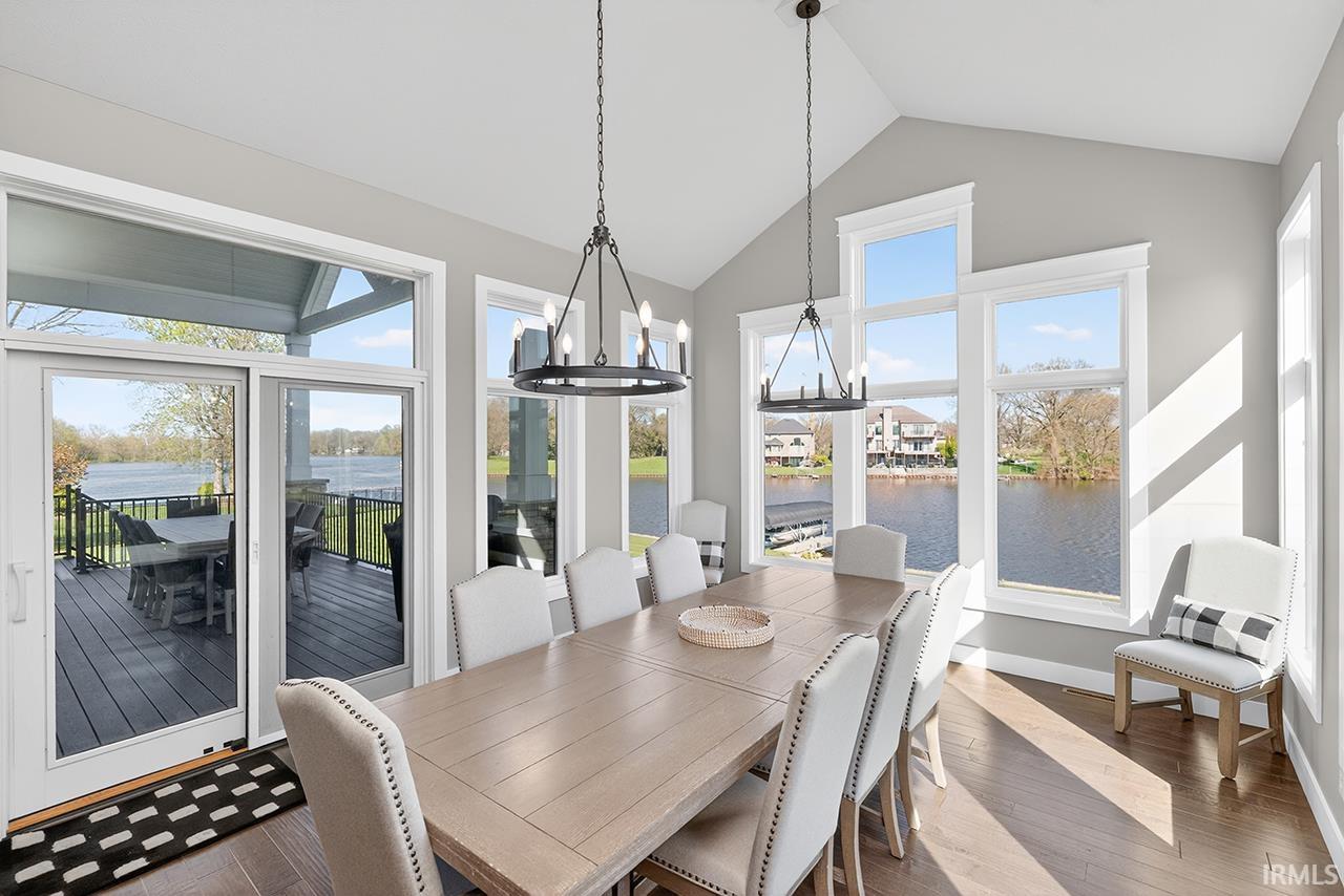 Vaulted ceilings highlight this dining space with multiple windows offering expansive water views