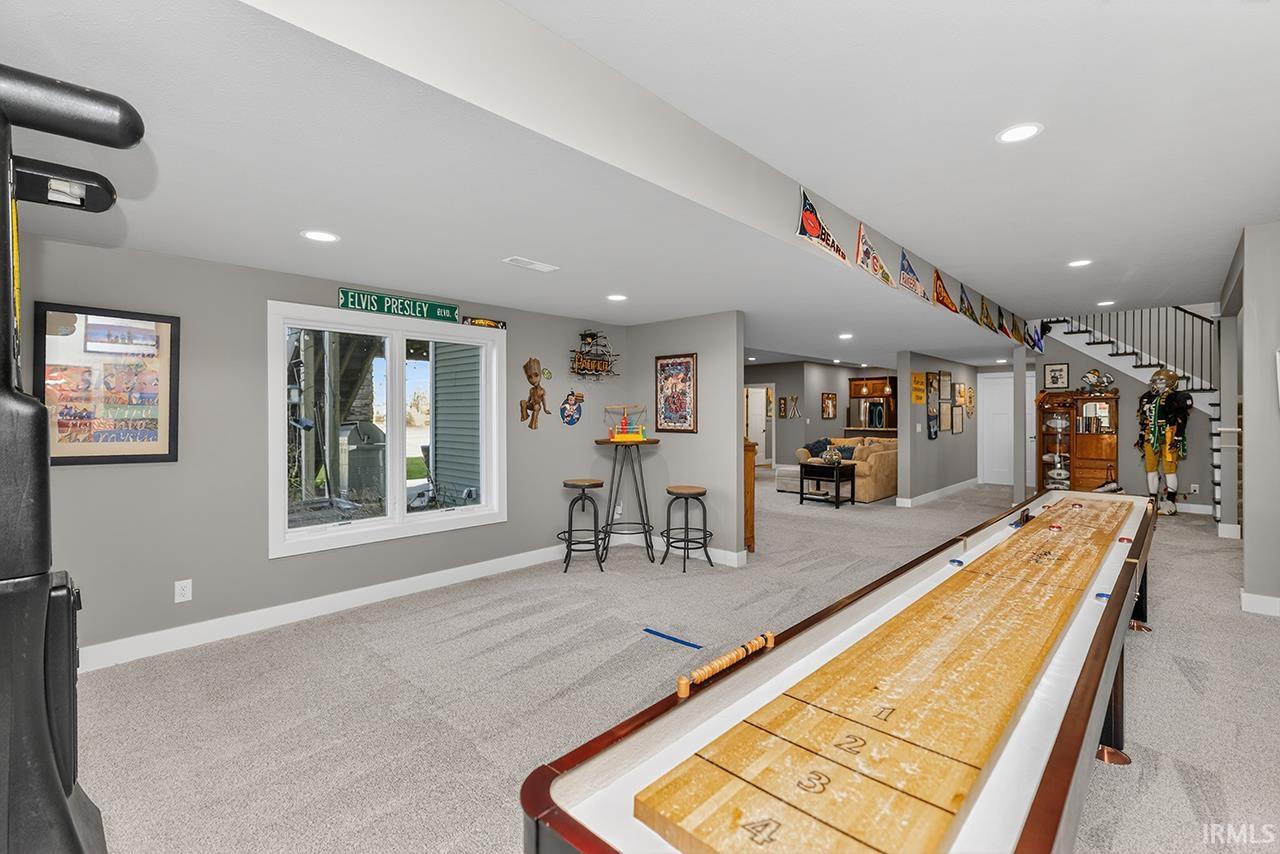 Spacious lower level featuring light gray walls, recessed lighting, and soft carpet flooring