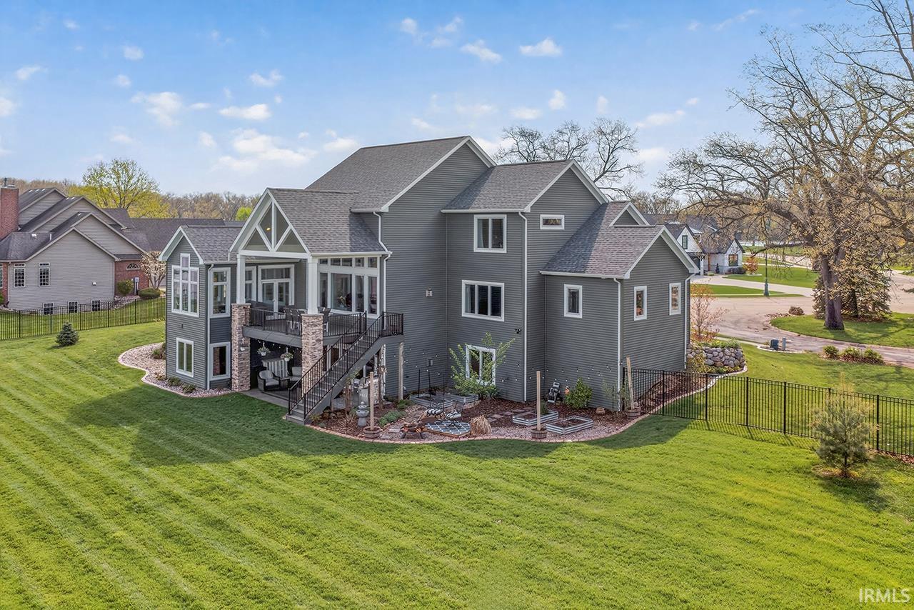 Expansive rear exterior featuring a two-story deck, covered patio, and large lawn