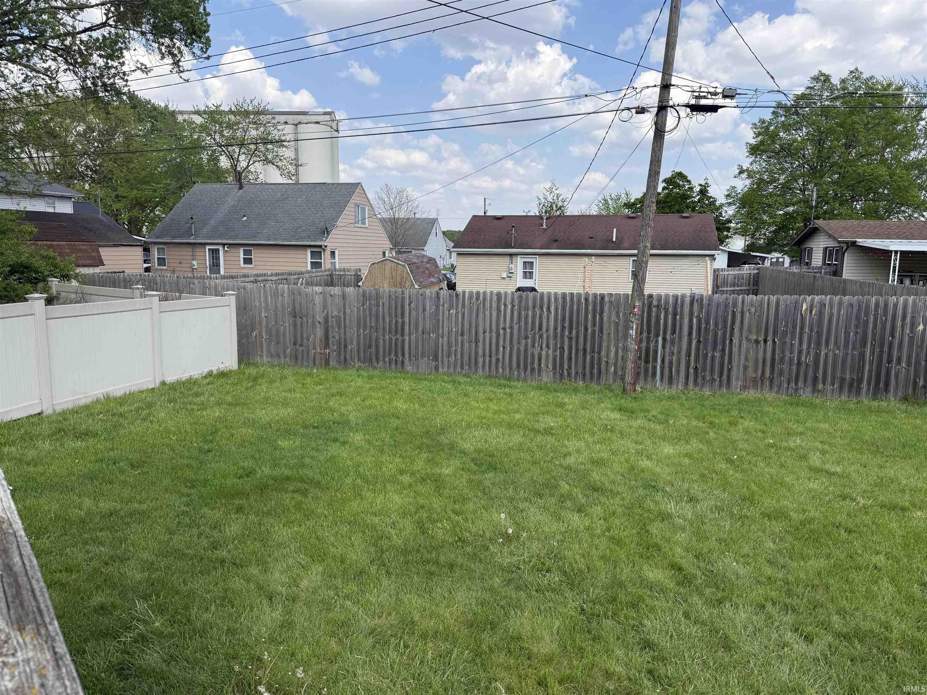 Expansive grass yard with a combination of vinyl and wood fencing