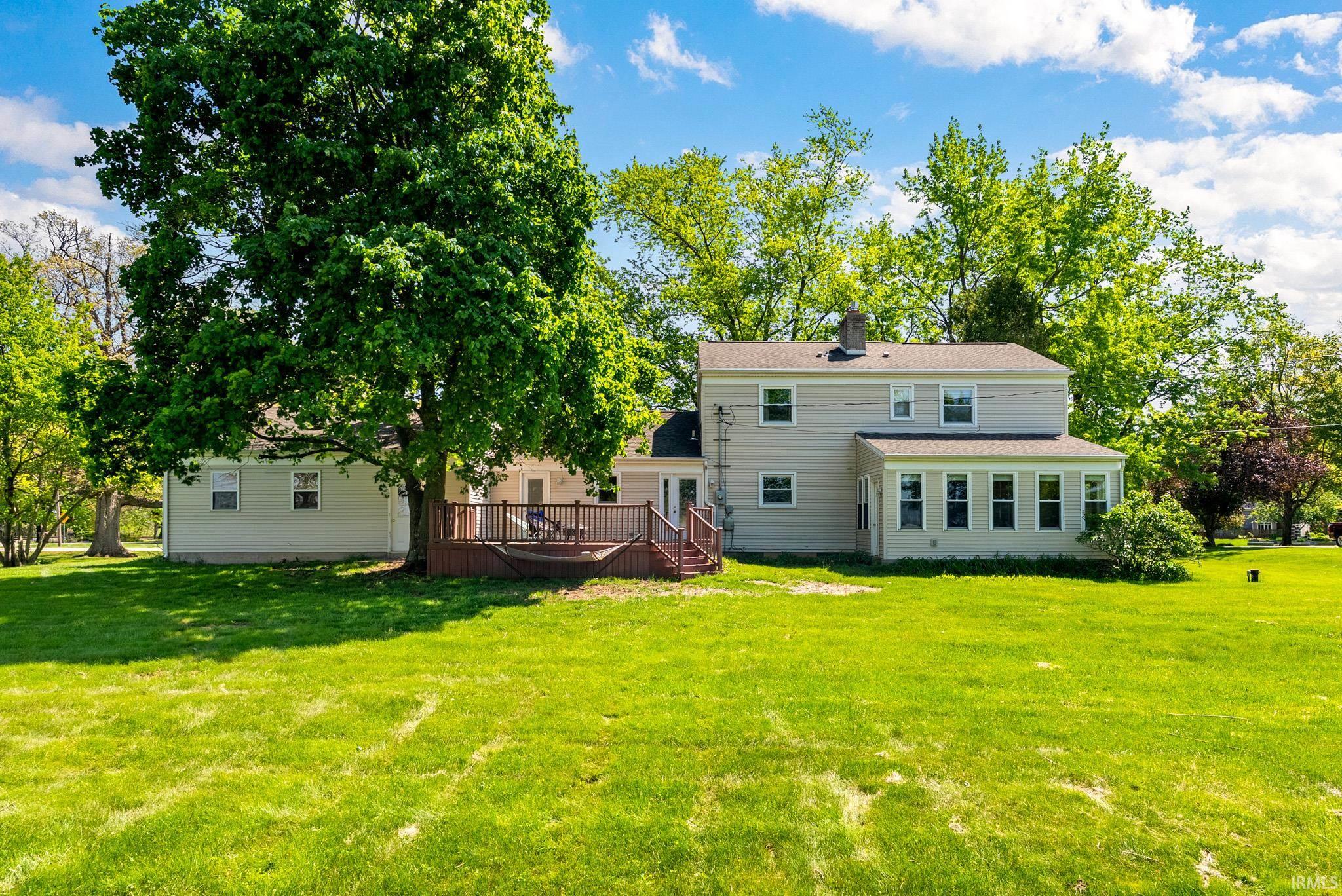 Expansive green lawn bordering a multi-level wood deck