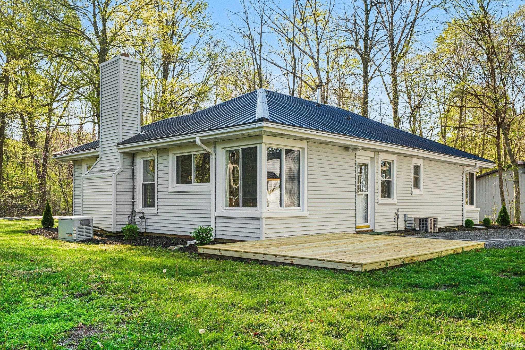 Light-colored siding exterior featuring a dark metal roof