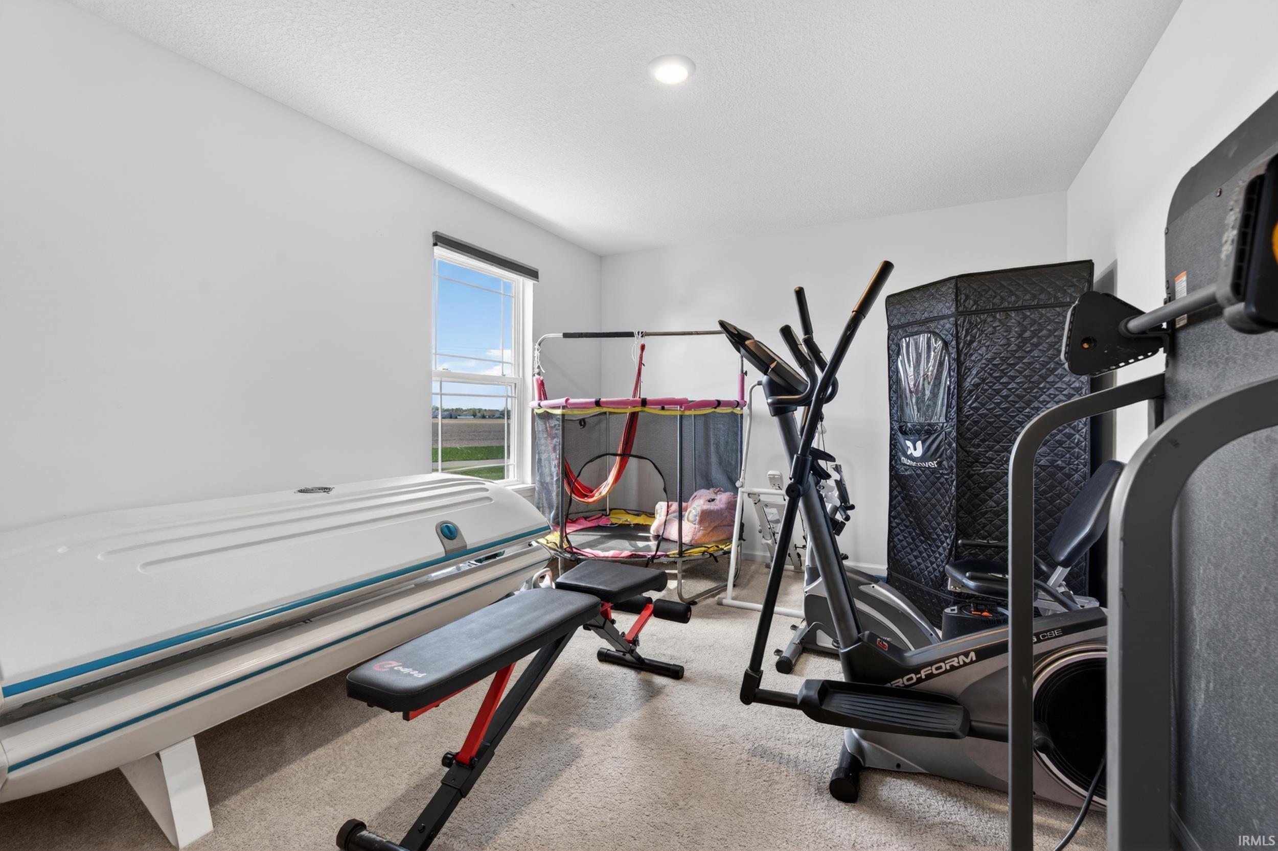 Spacious room featuring neutral carpeting, a single window, and recessed lighting