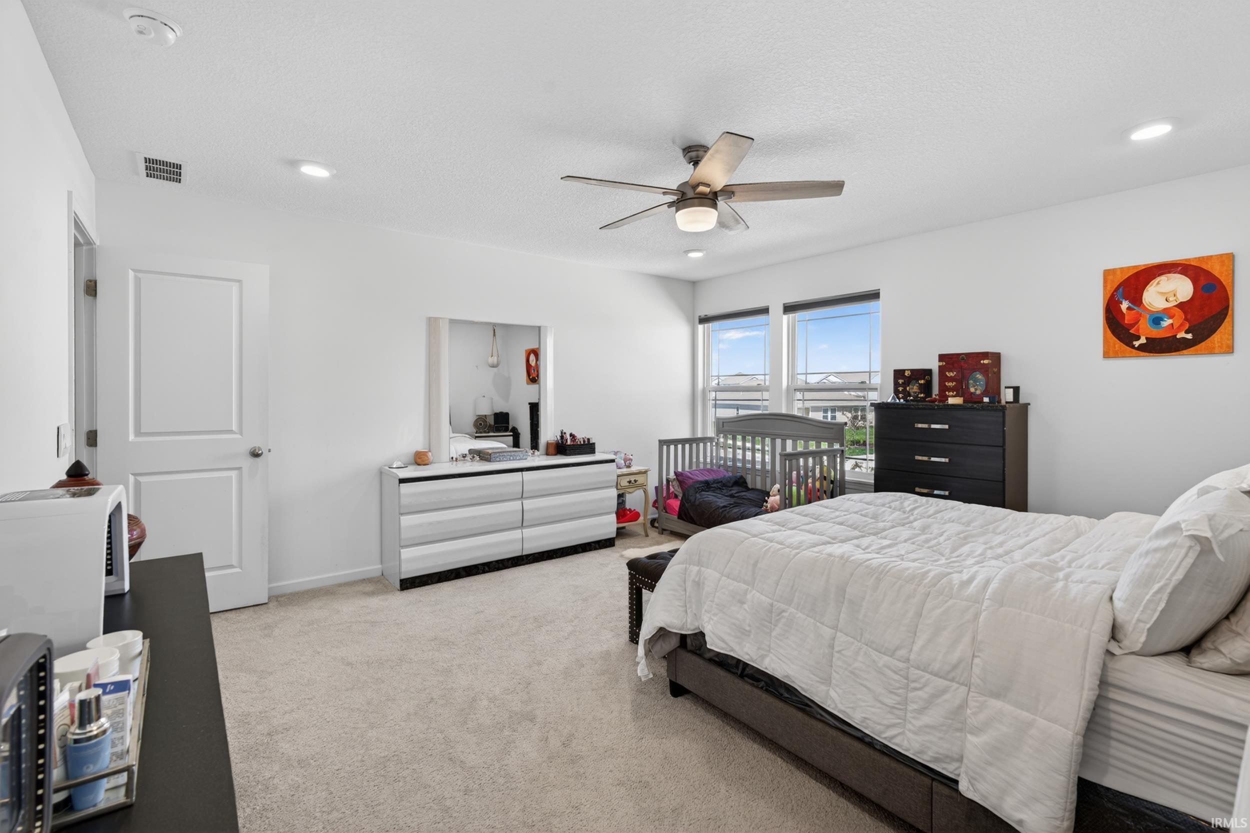 Spacious room featuring neutral carpeting, a ceiling fan with integrated lighting, and recessed ceiling lights