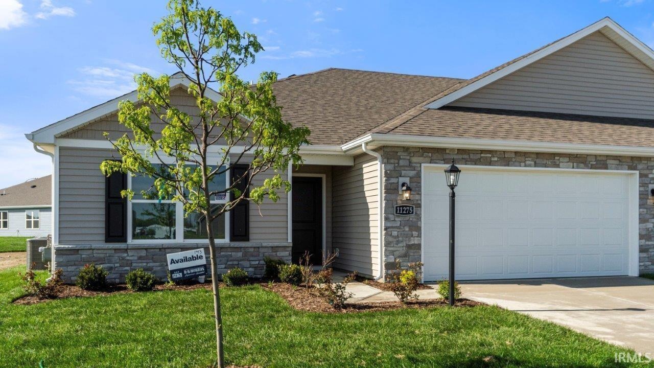 Contemporary ranch-style home featuring a two-car garage, stone veneer accents, and horizontal siding