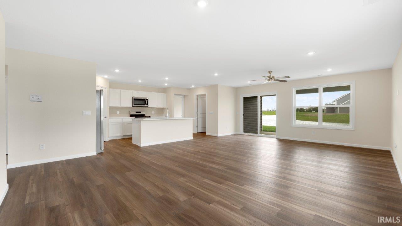 Open-concept living area featuring wood-finish flooring, recessed lighting, and a ceiling fan