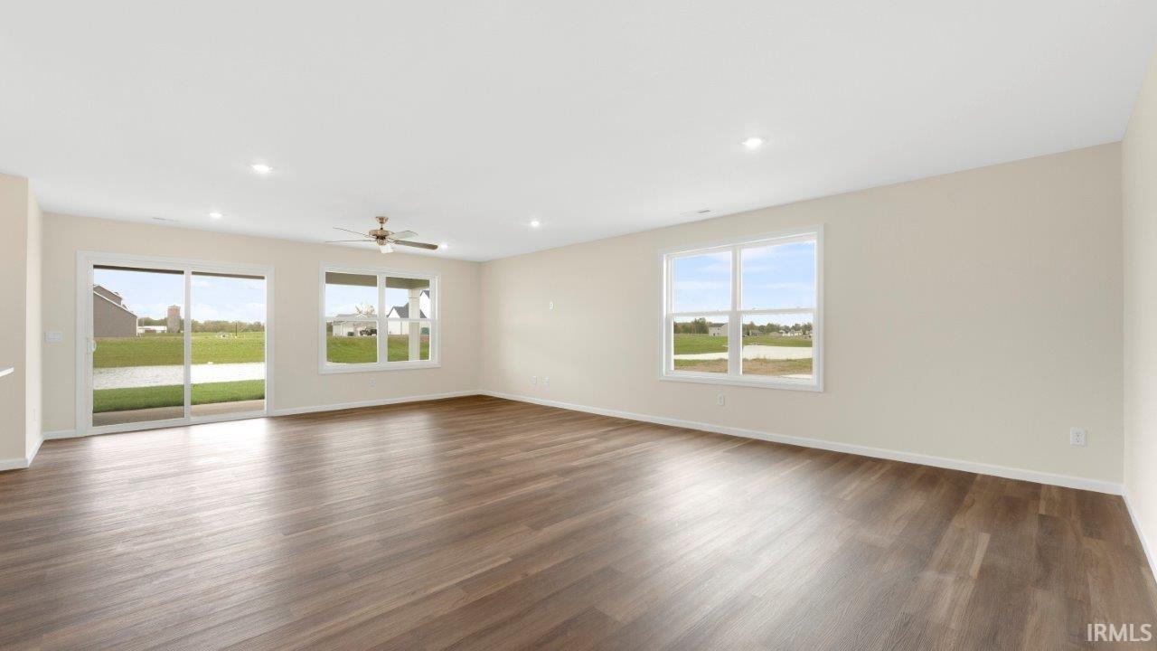 Spacious room featuring wood-finish flooring, recessed lighting, and a ceiling fan
