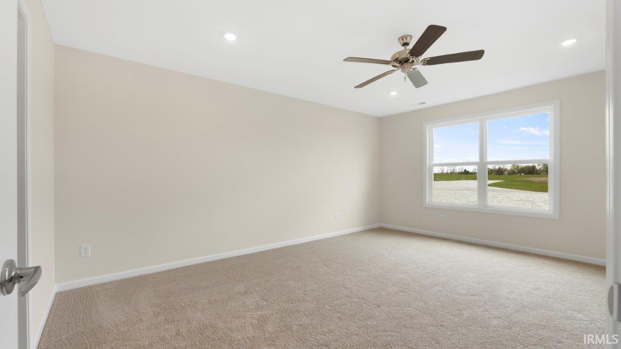 Carpeted room with a large window, a ceiling fan, and recessed lighting