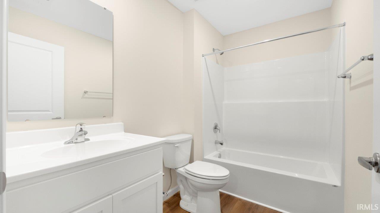 Bathroom with white vanity, integrated sink, chrome faucet, and mirrored medicine cabinet