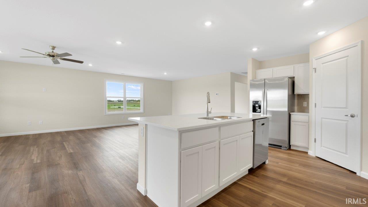 Open-concept living space featuring wood-finish flooring, recessed lighting, and a ceiling fan