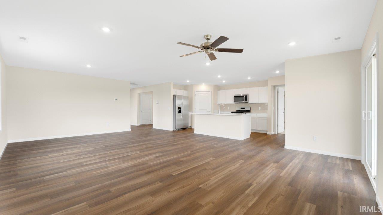 Open-concept living area featuring wood-finish flooring, recessed lighting, and a ceiling fan