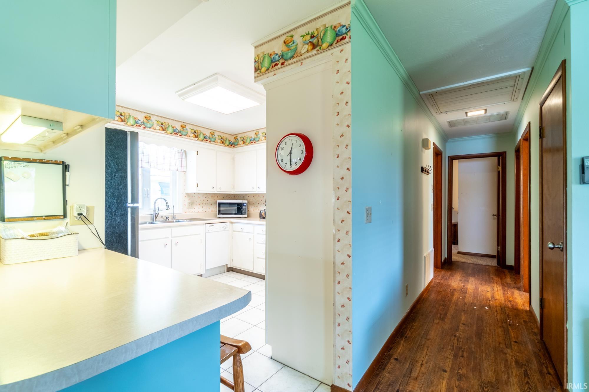 Kitchen area featuring white cabinetry, light-colored countertops, and white tile flooring