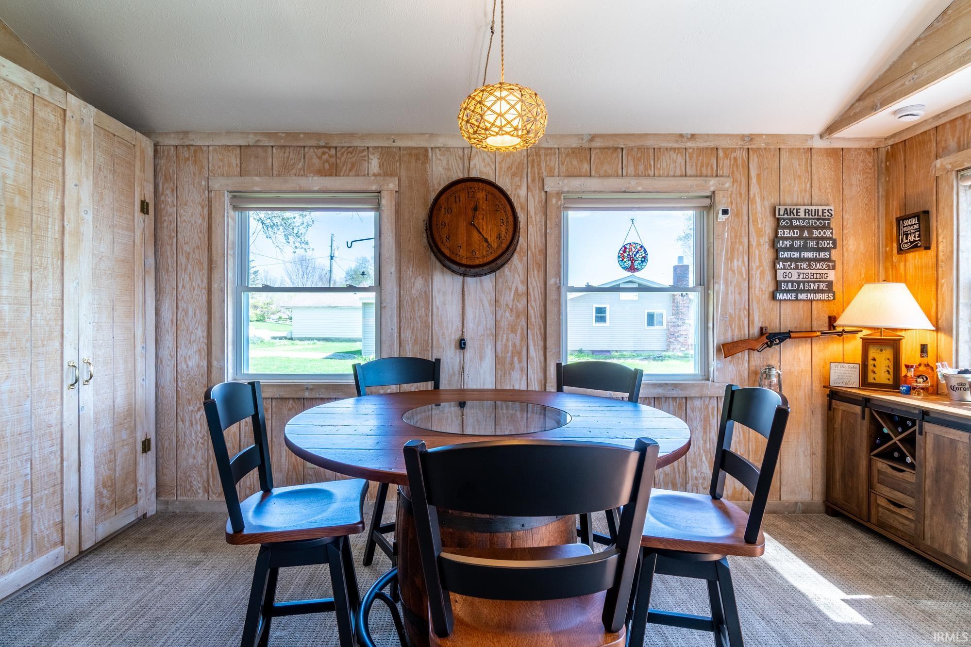 Wood-paneled room featuring a built-in storage cabinet and two windows