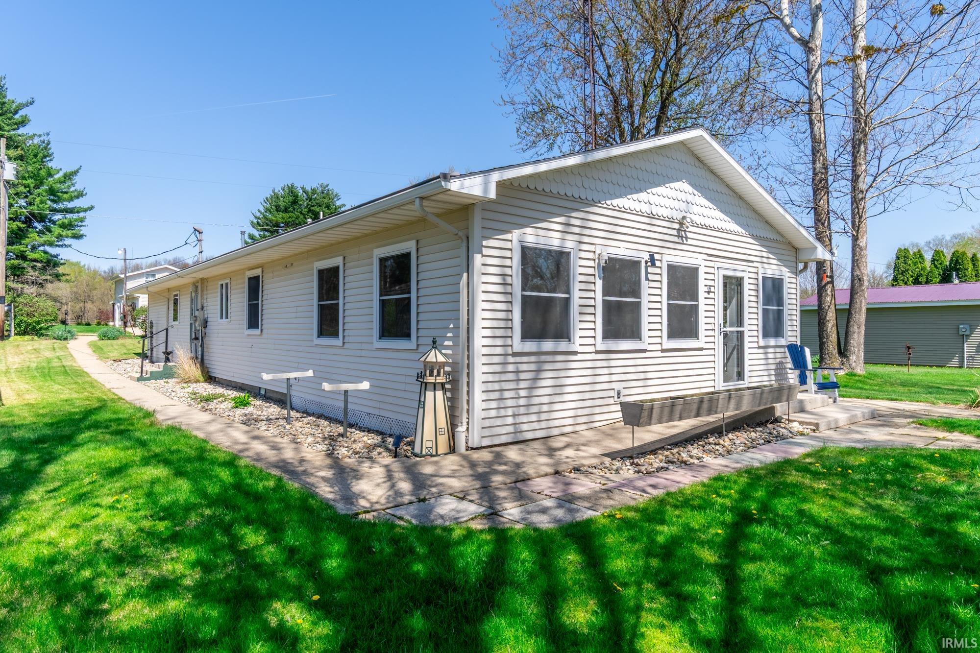 White siding exterior featuring multiple windows and a gabled roofline
