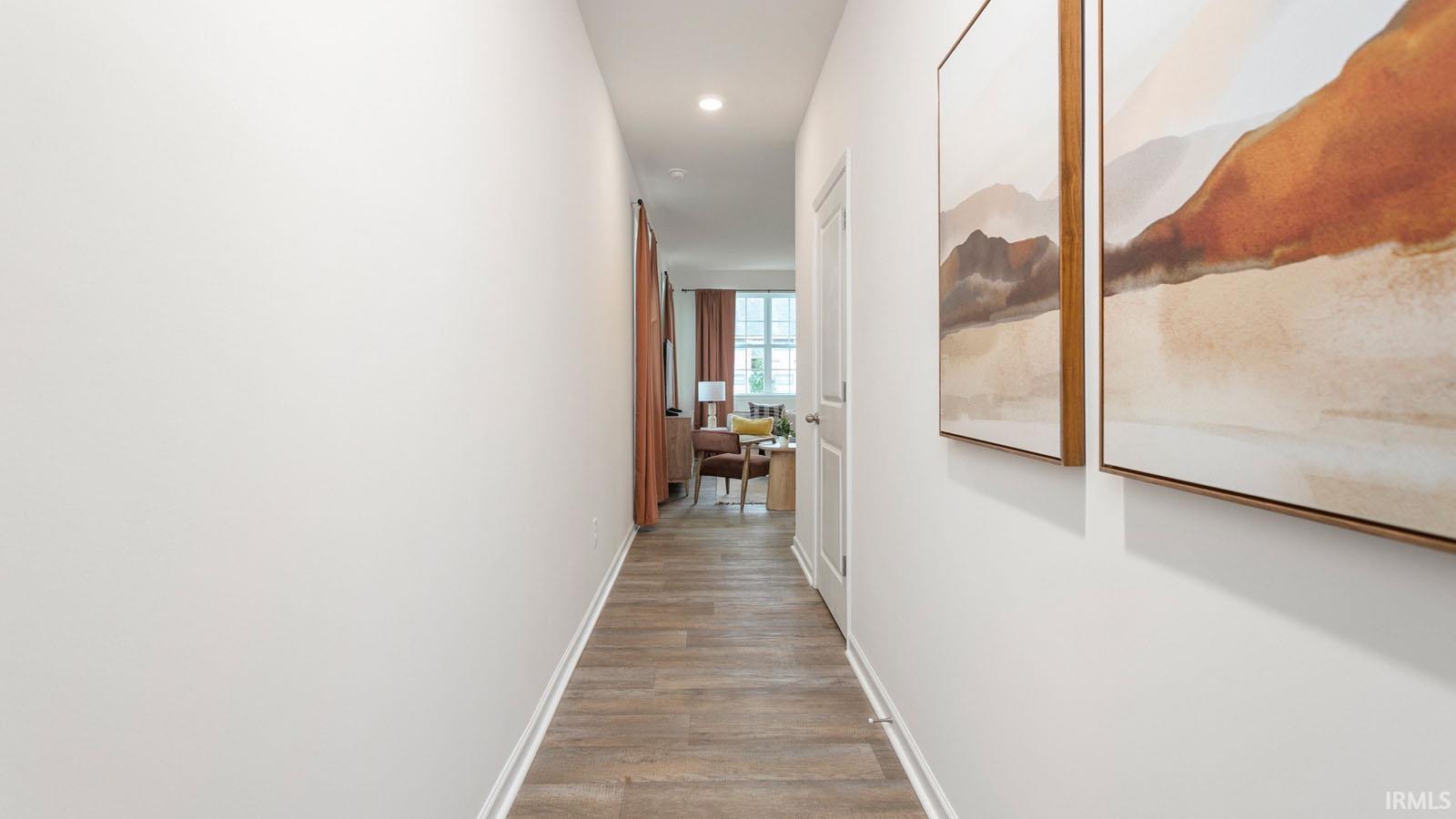 Hallway featuring wood-finish flooring, recessed lighting, and white baseboards