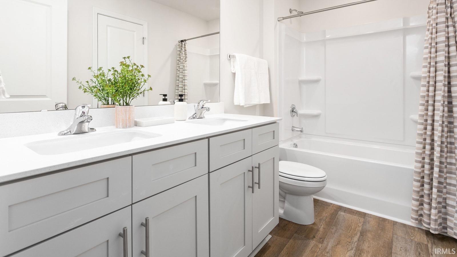 Dual vanity with light gray shaker-style cabinetry, white countertops, and integrated sinks