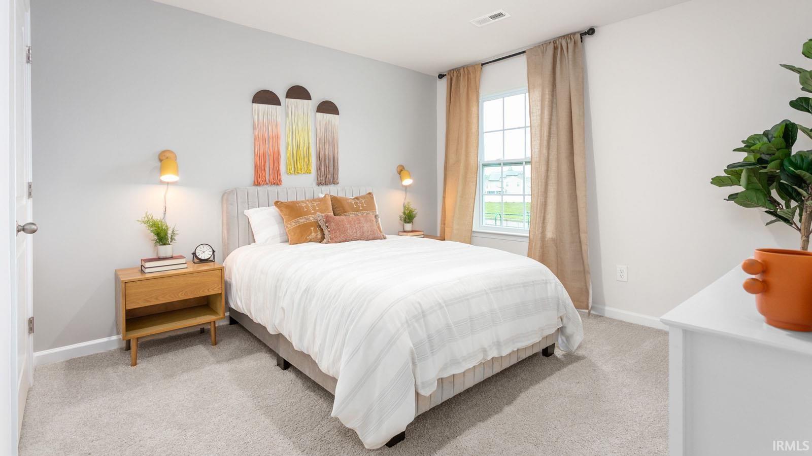 Bedroom featuring light gray walls, plush gray carpeting, and a window with natural light