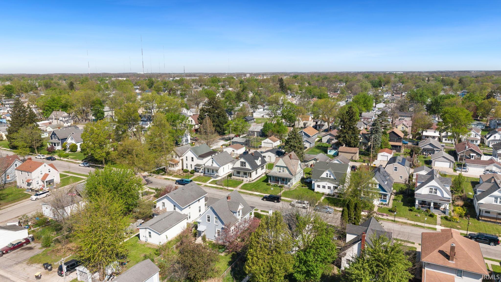 Aerial perspective showcasing a residential neighborhood with a consistent architectural style, mature trees, and street-level parking