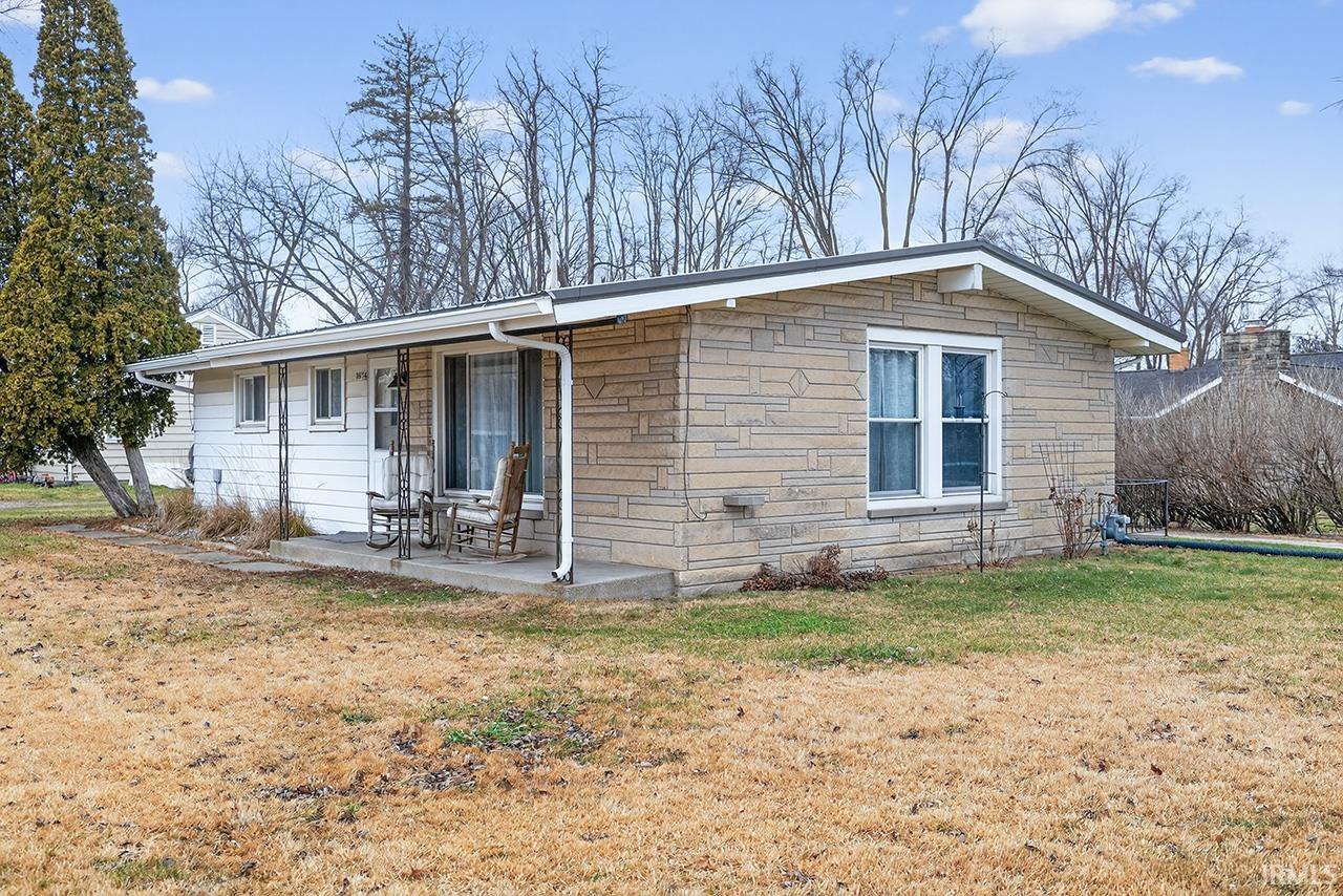 View of front of home with stone siding and a front lawn