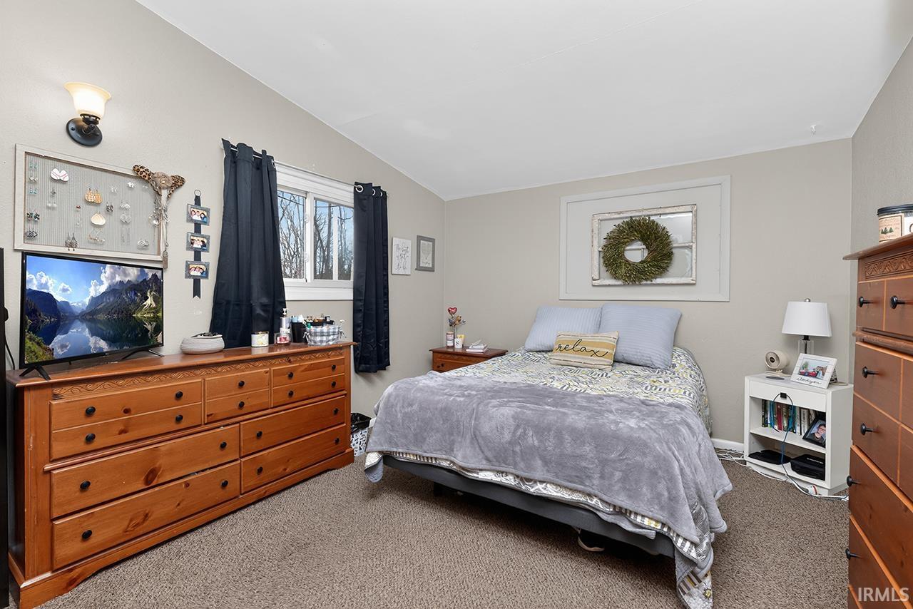 Carpeted bedroom with vaulted ceiling