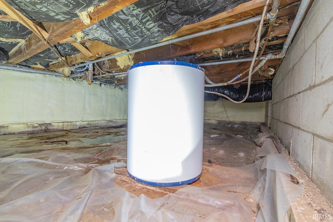 Utility room featuring crawl space and water heater