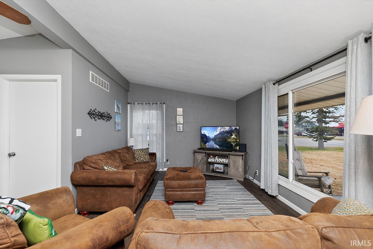 Living area with vaulted ceiling and wood finished floors