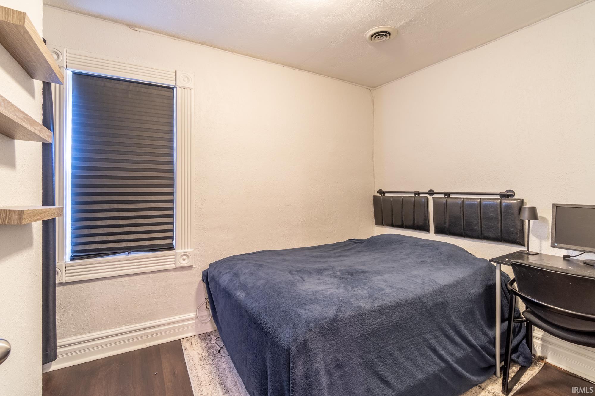Room featuring dark wood-finish flooring and light-toned walls