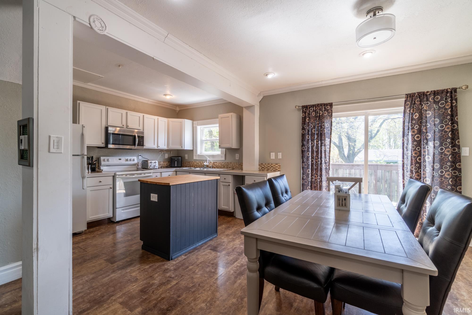 Open-concept kitchen and dining area featuring wood-finish flooring