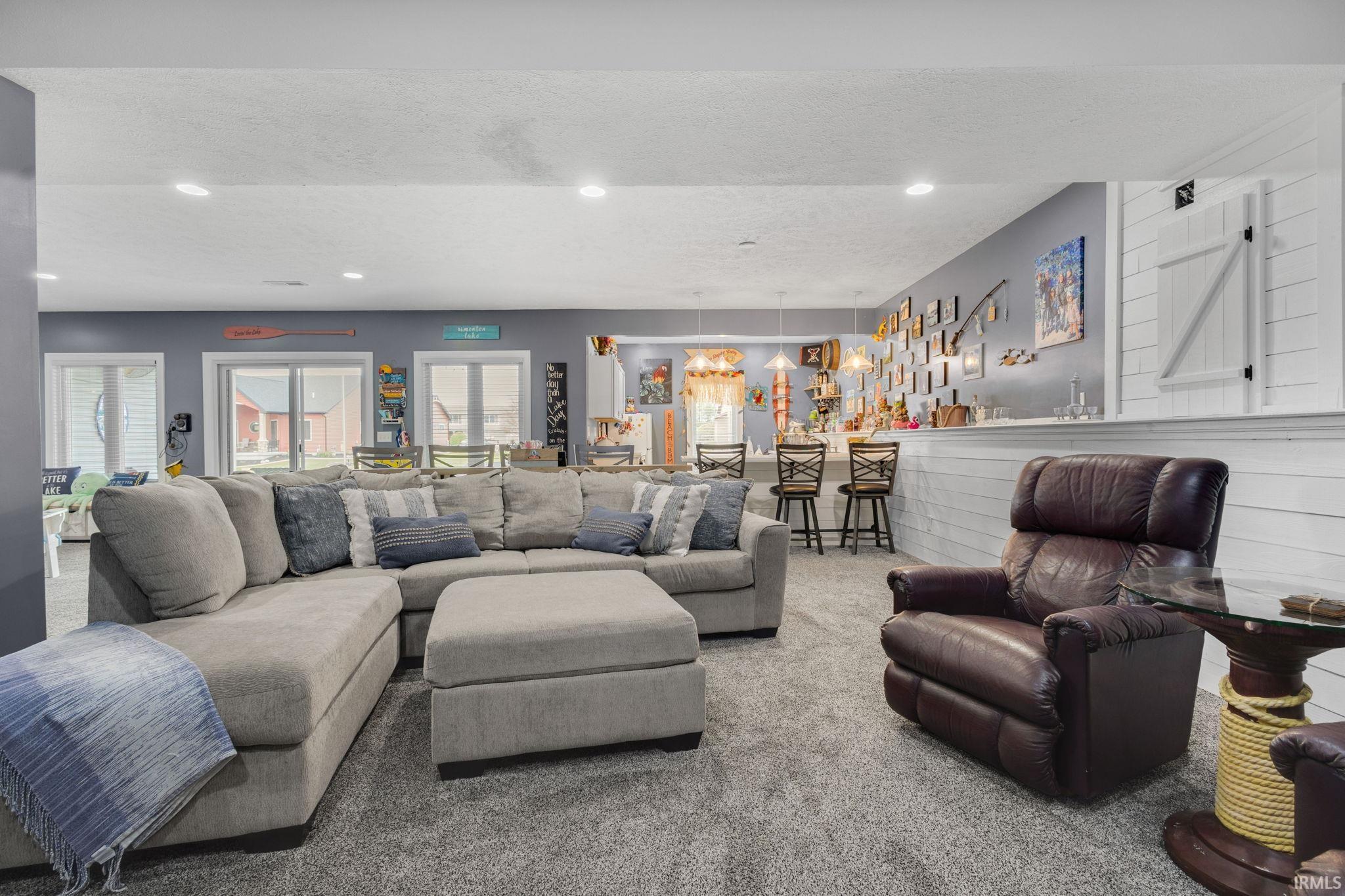 Spacious recreational room featuring gray carpeting and recessed lighting