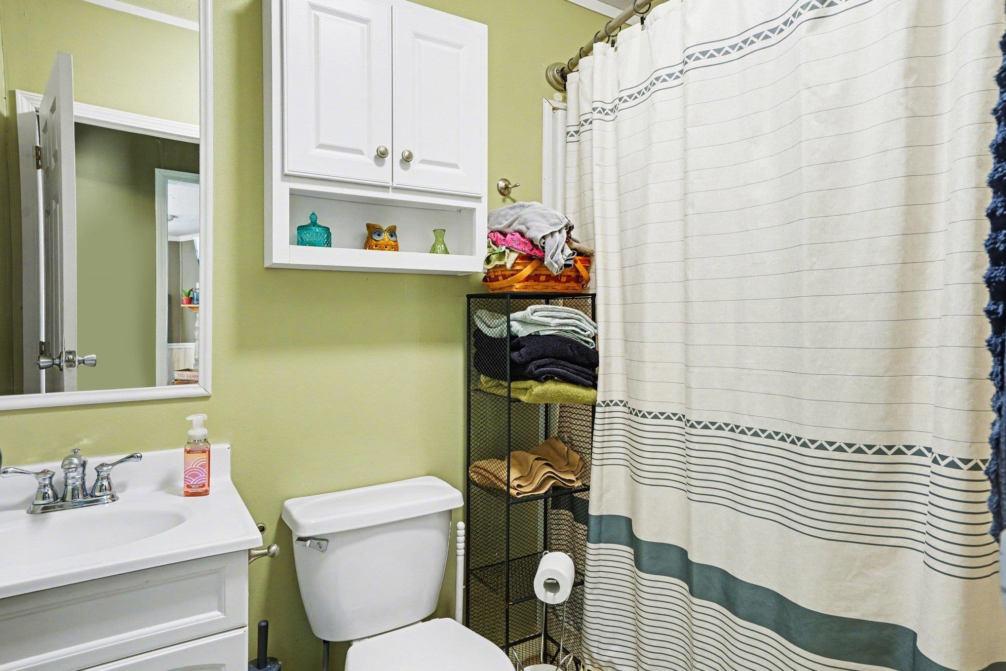 Bathroom featuring a white vanity with an integrated sink, polished chrome faucet, and white wall-mounted medicine cabinet