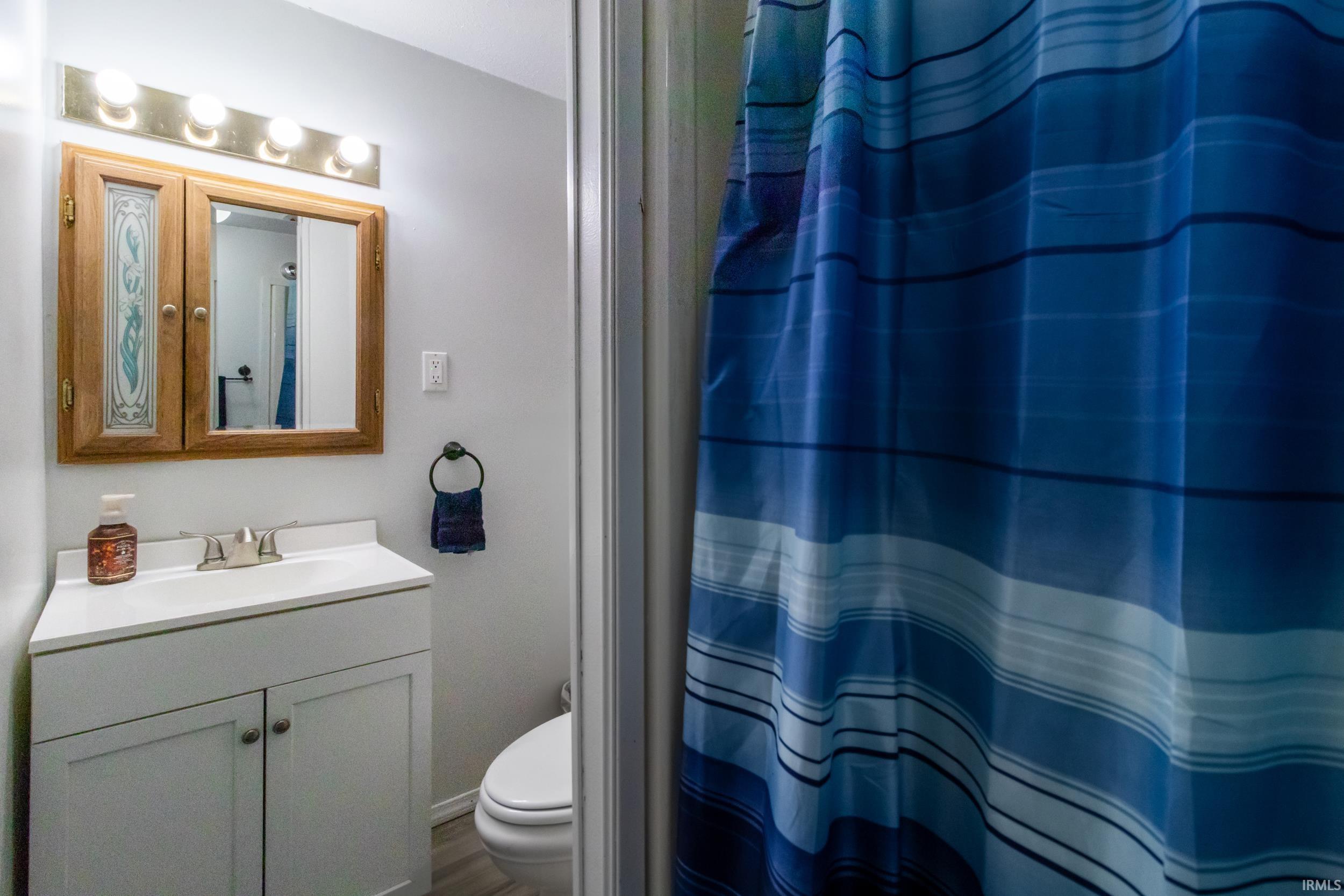 Bathroom vanity with a white countertop and base cabinetry, featuring an integrated sink with a chrome faucet