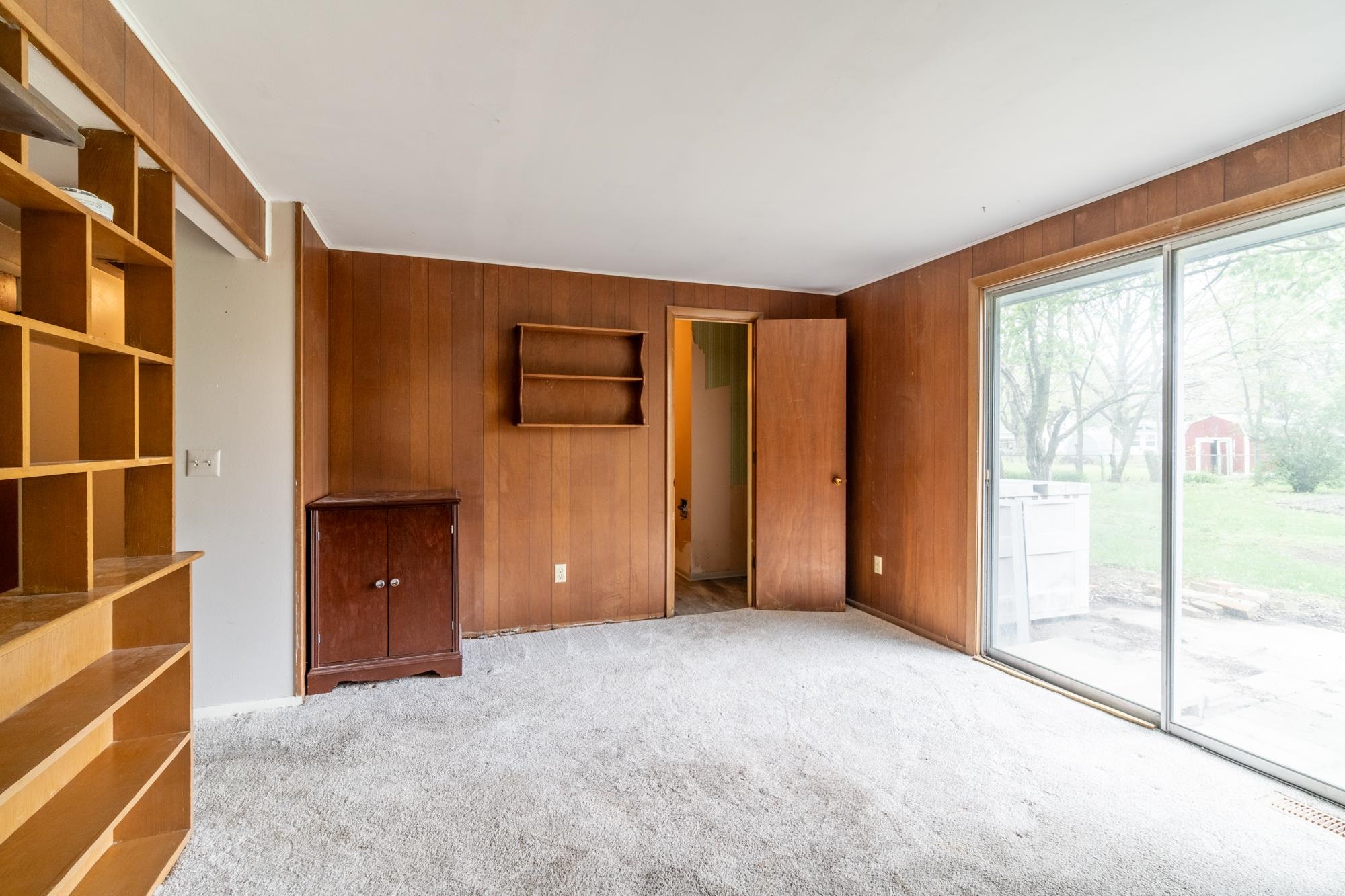 Wood paneling throughout the room, complemented by a built-in shelving unit