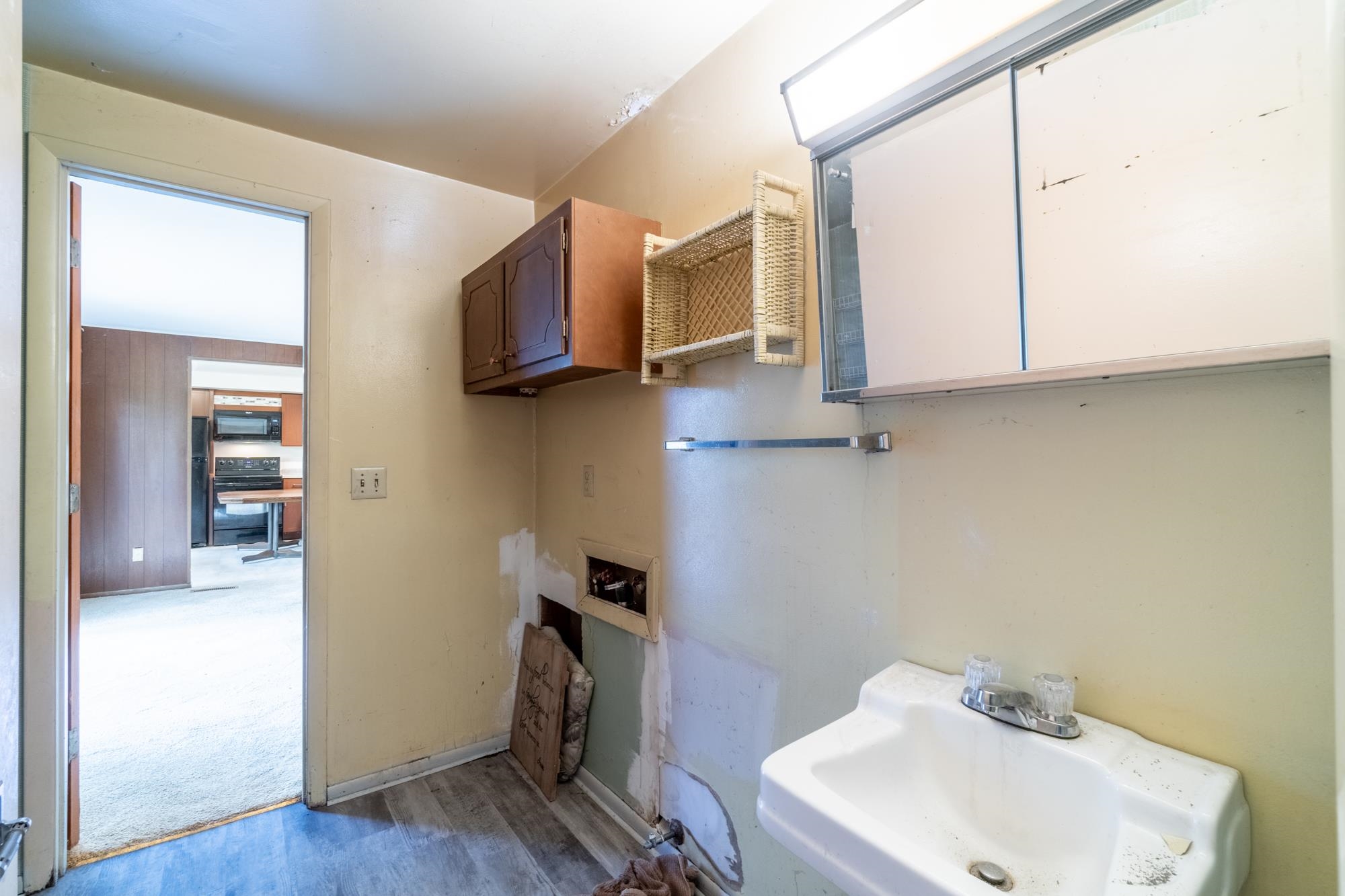 Utility area featuring wood-finish flooring and a wall-mounted sink