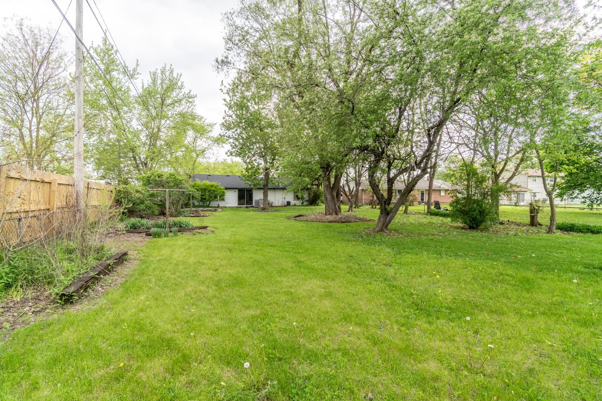 Expansive green lawn featuring mature trees
