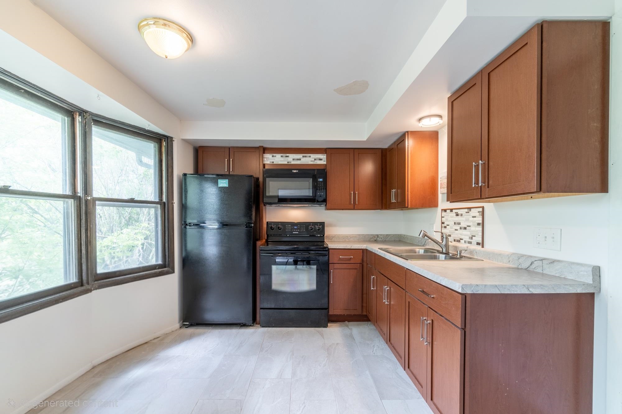 Kitchen featuring wood-finish cabinetry, light-toned countertops, tile flooring, and a black appliance suite including a refrigerator, range, and microwave