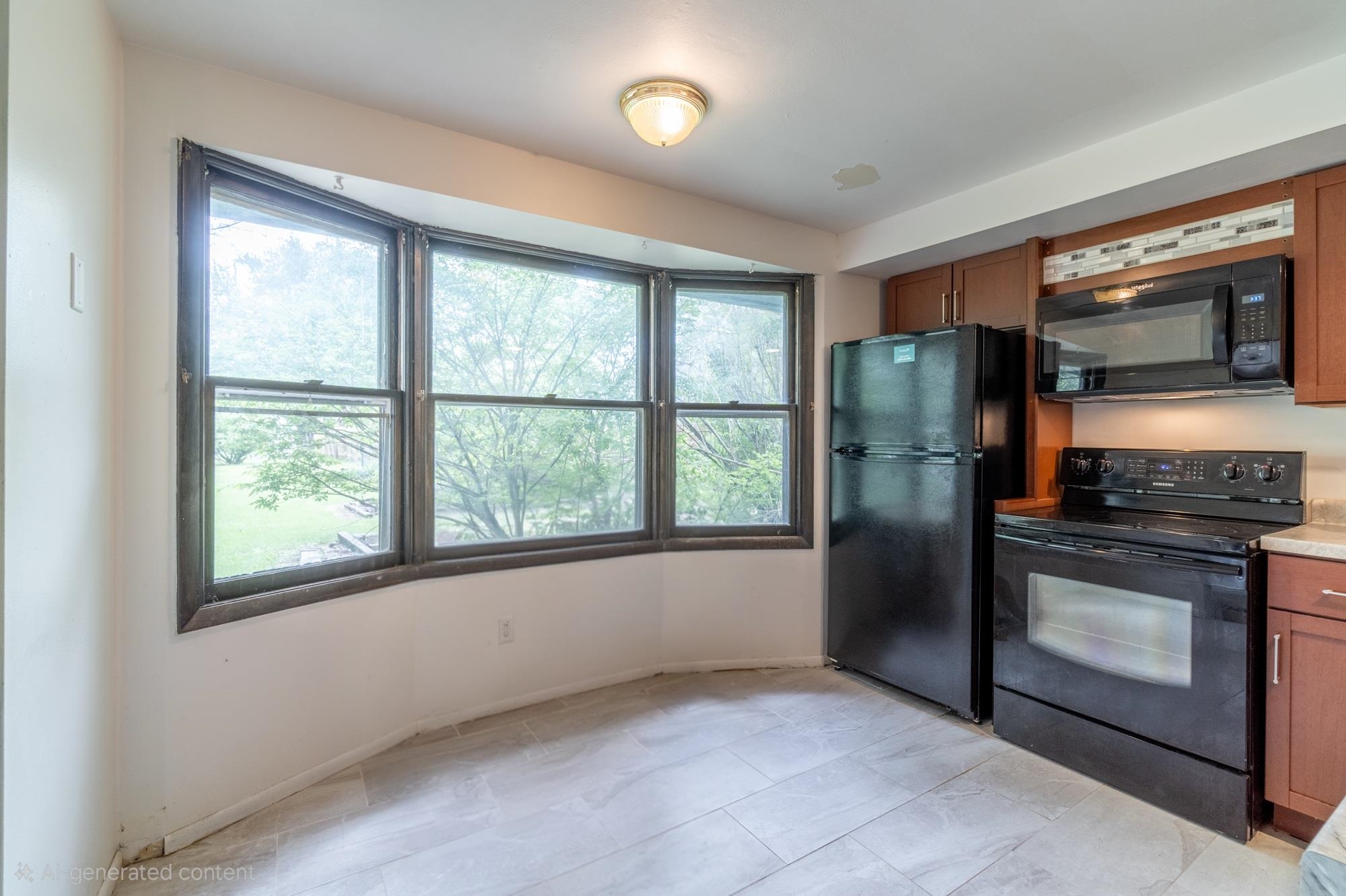 Kitchen space featuring a bay window, wood-finish cabinetry, ceramic tile flooring, and integrated black appliances