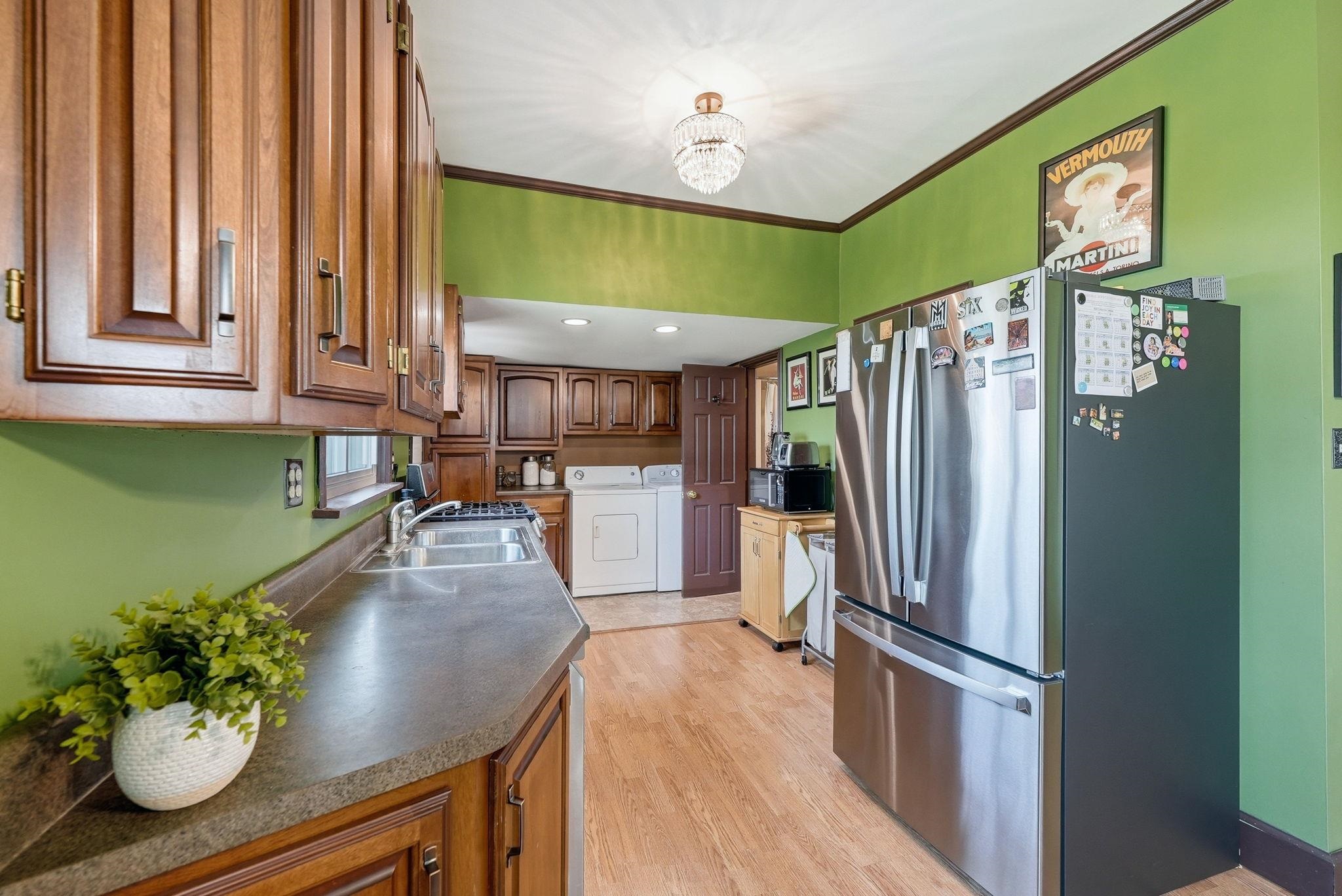 Kitchen featuring wood-finish flooring, dark wood cabinetry, and a double basin stainless steel sink