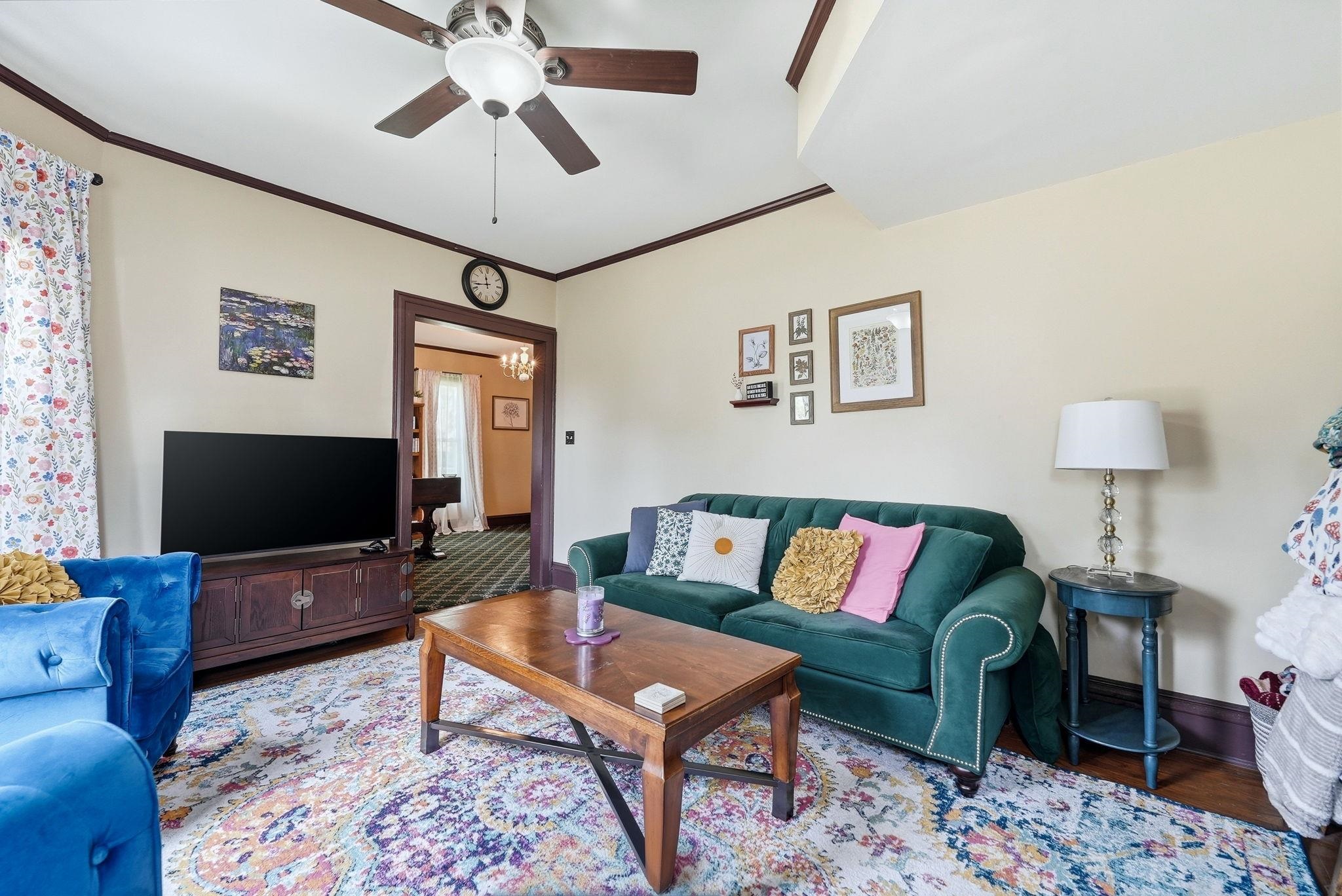 Living area featuring dark wood trim, a ceiling fan, and a built-in media console