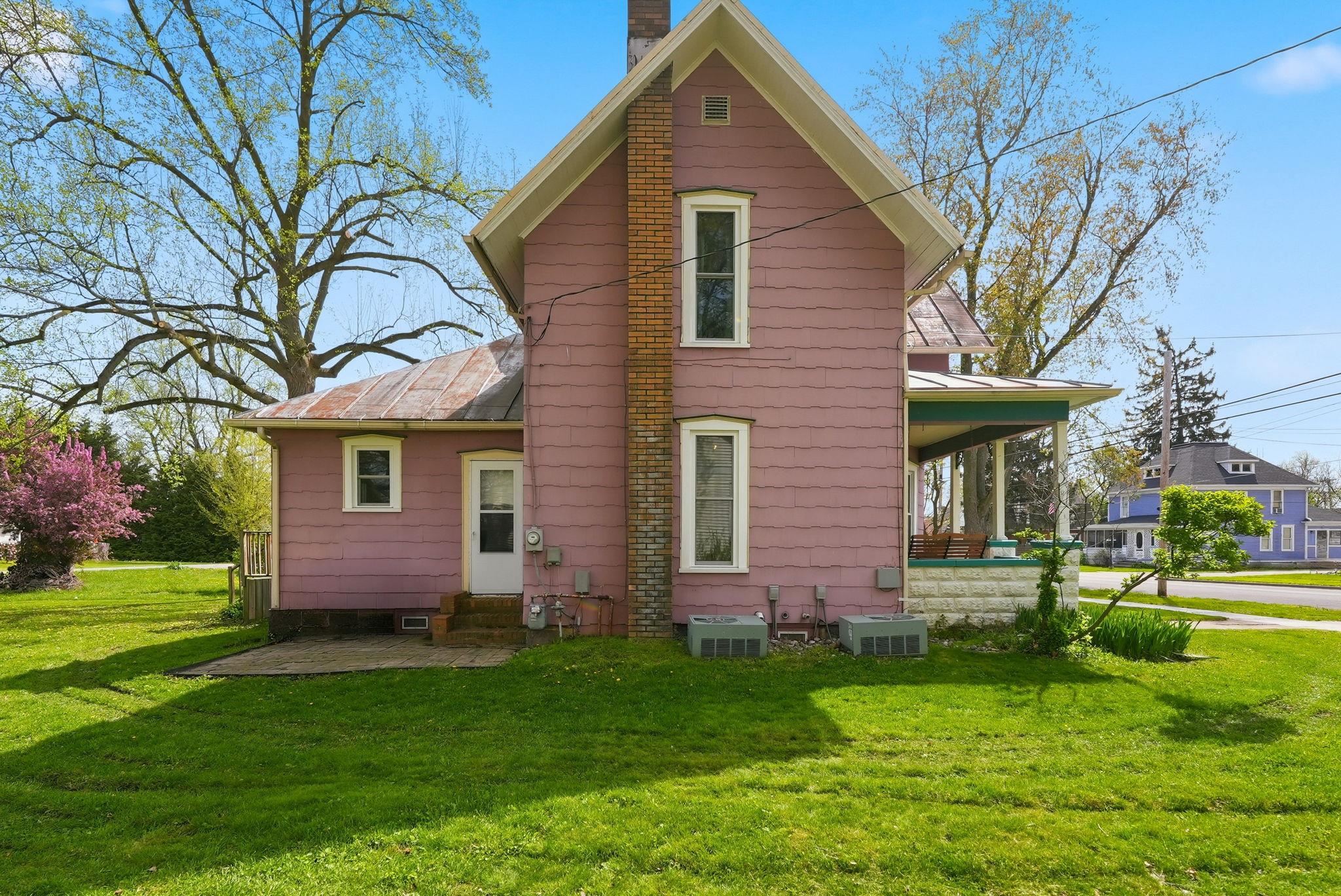 Pink siding exterior with a prominent brick chimney
