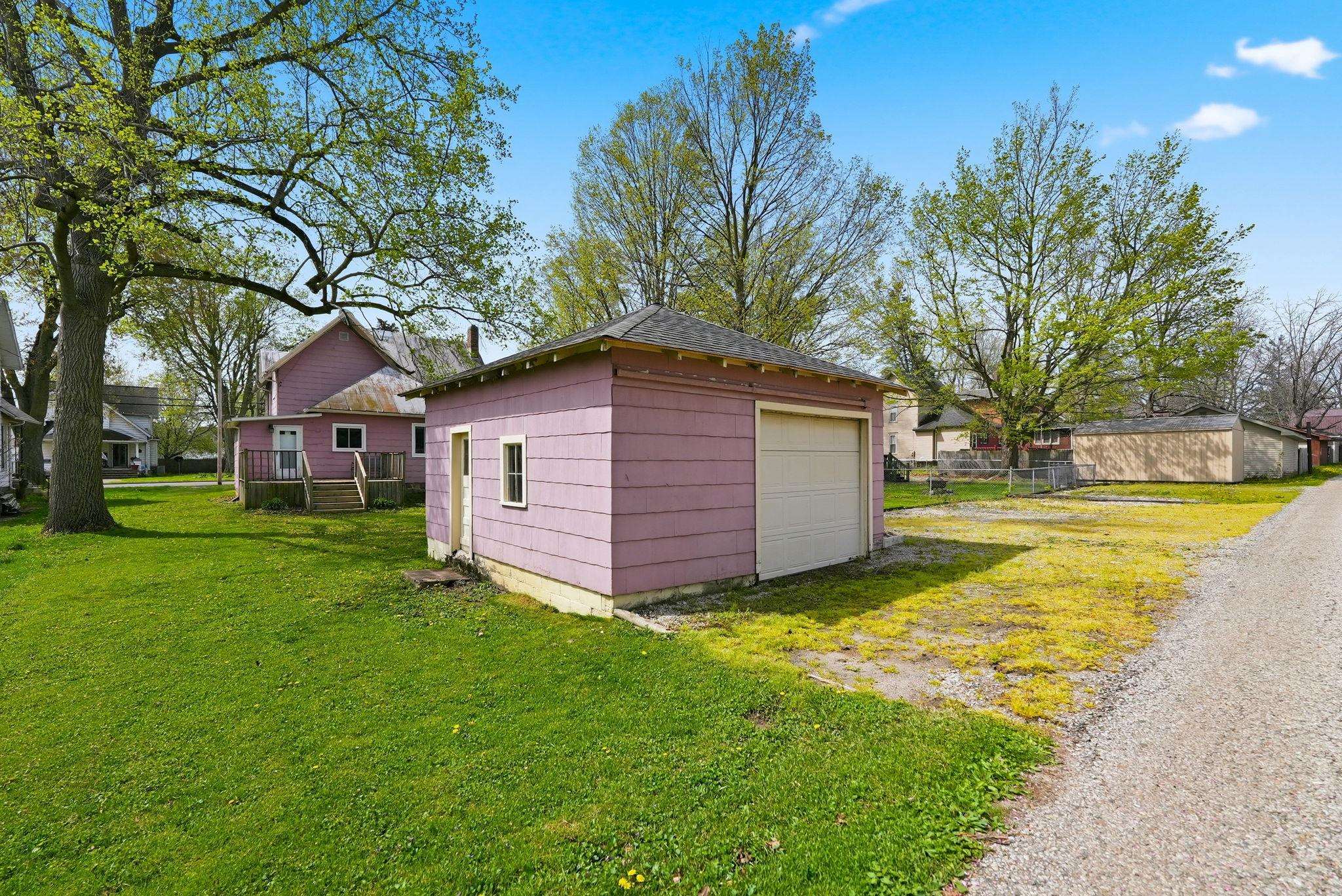 Detached single-car garage featuring a roll-up door and side entry