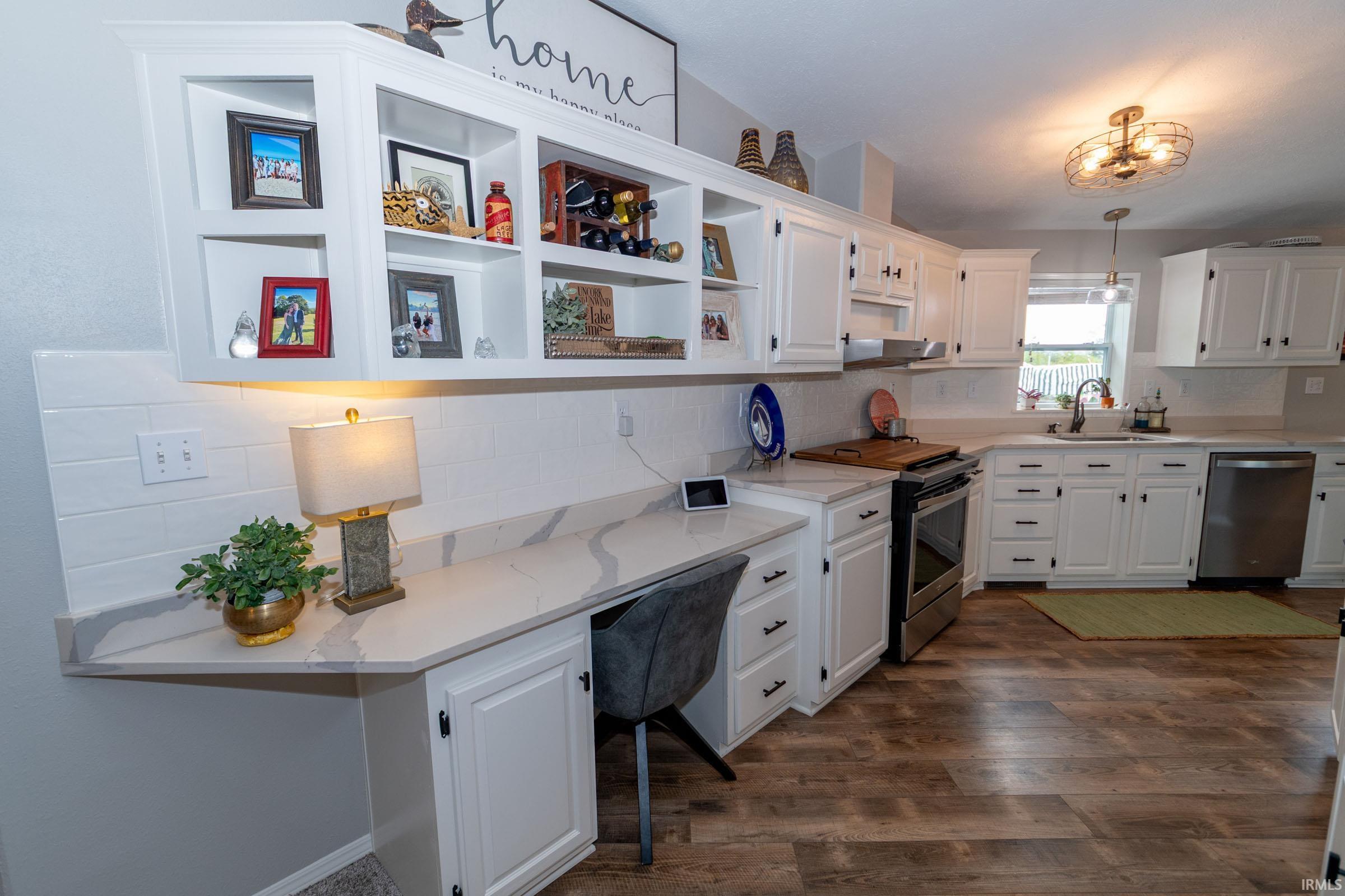 Kitchen featuring wood-finish flooring, white cabinetry with black hardware, and stone countertops