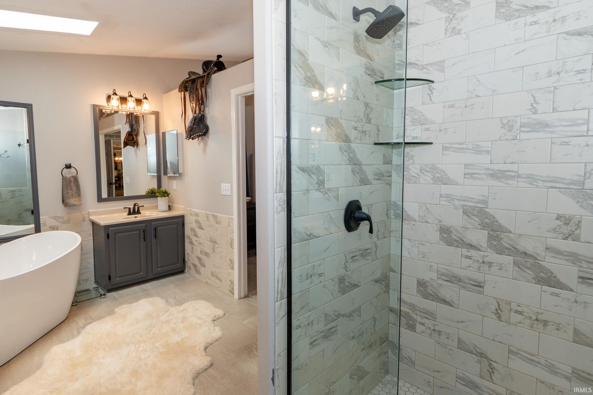 Glass-enclosed shower with subway tile surround and matte black fixtures