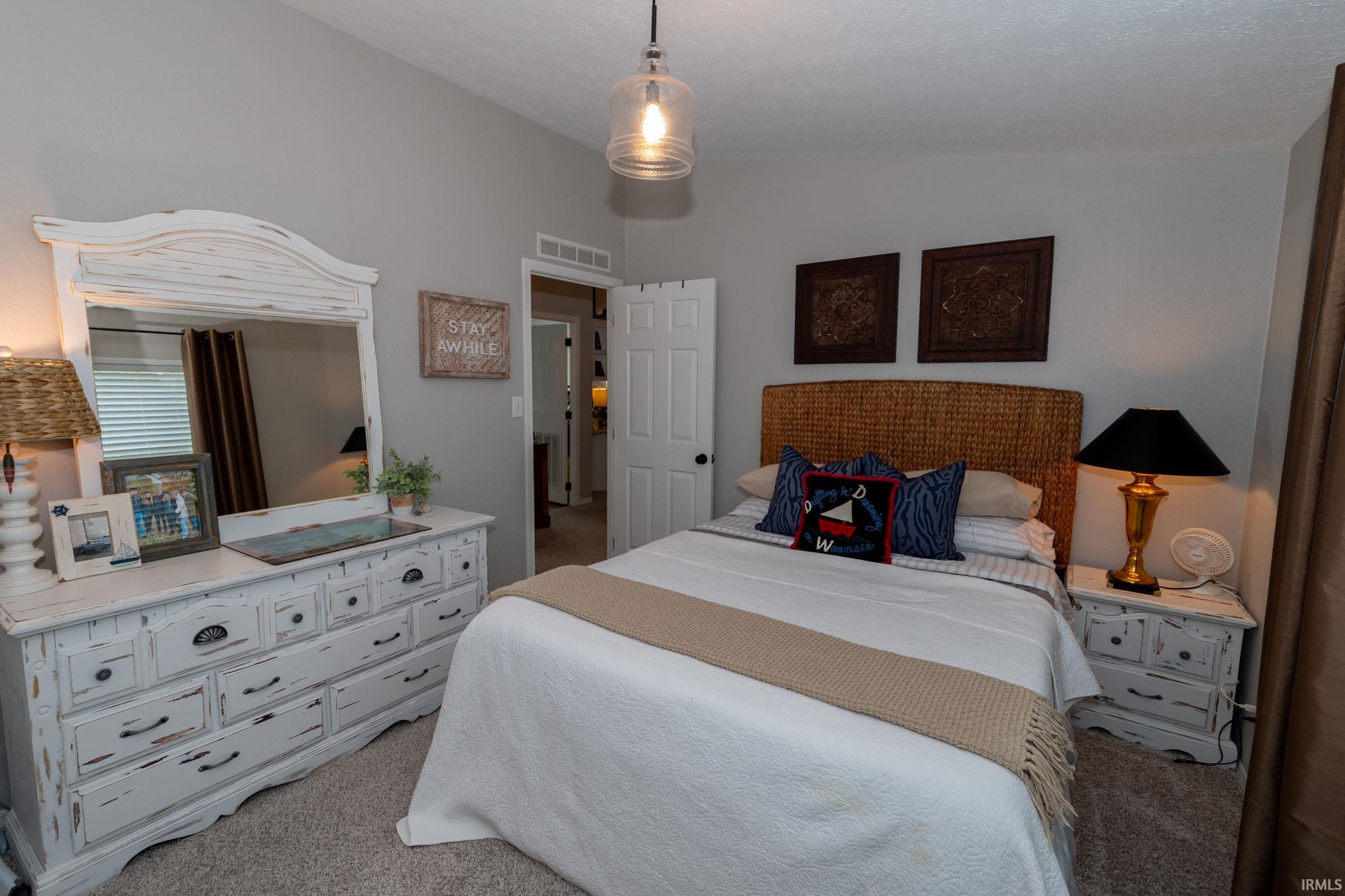 Neutral-toned walls complement the textured woven headboard