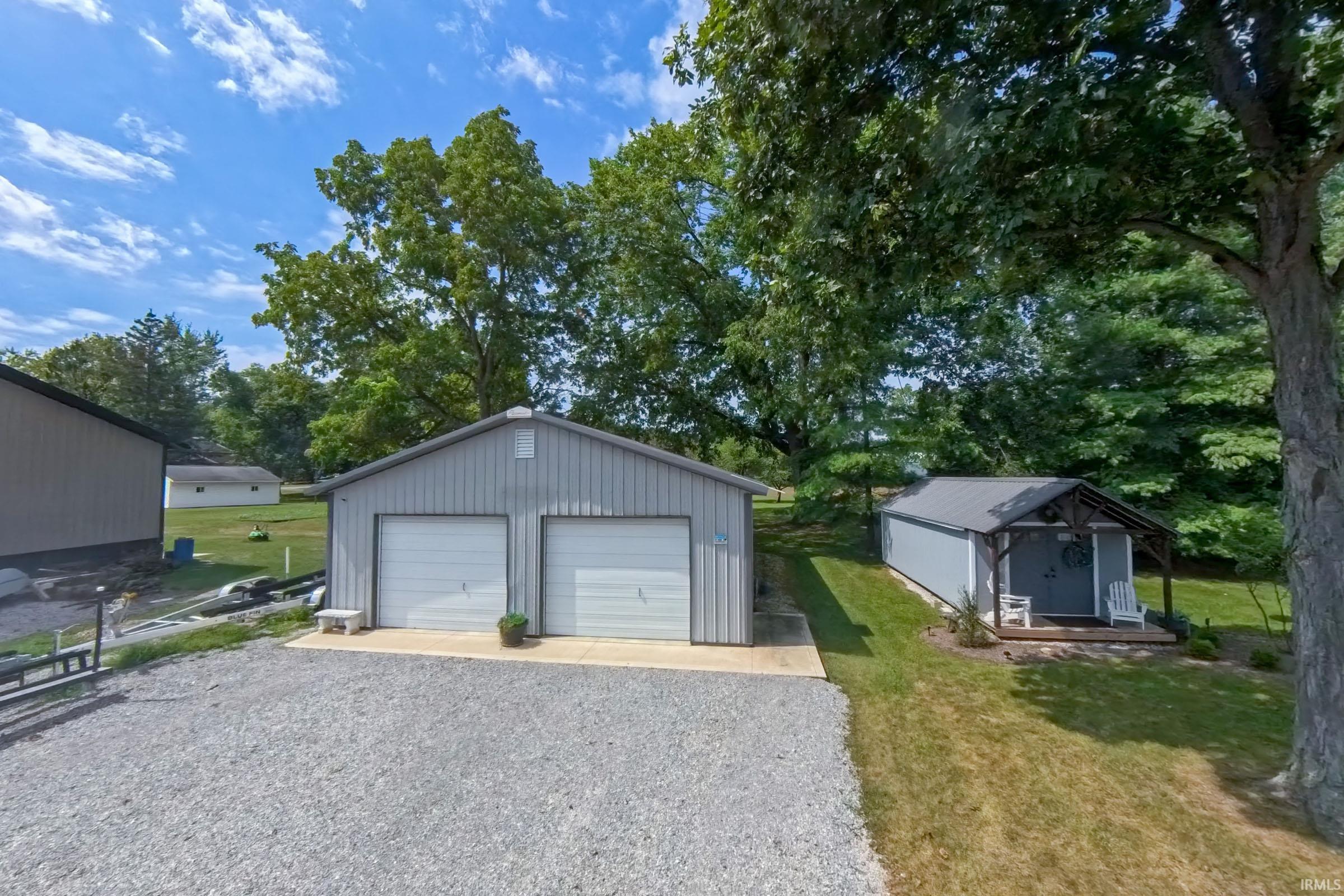 Two-car detached garage with gravel driveway and concrete pad